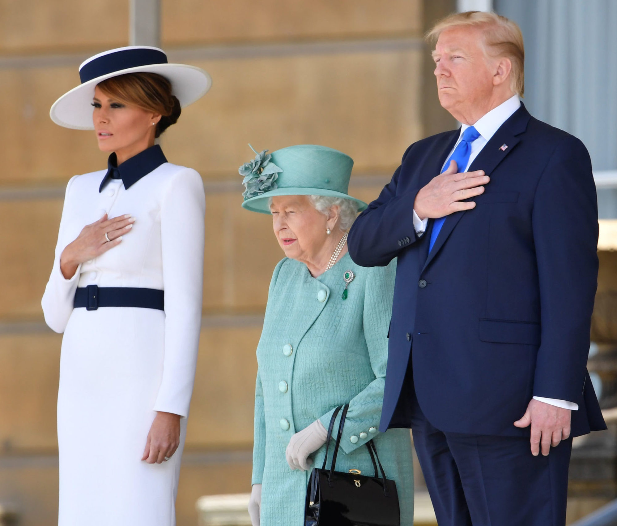 LONDON, ENGLAND - JUNE 03: Queen Elizabeth II stands with US President Donald Trump and US First Lady Melania Trump as they listen to the US national anthem during a welcome ceremony at Buckingham Palace on June 3, 2019 in London, England. (Photo by Toby Melville - WPA Pool/Getty Images)
