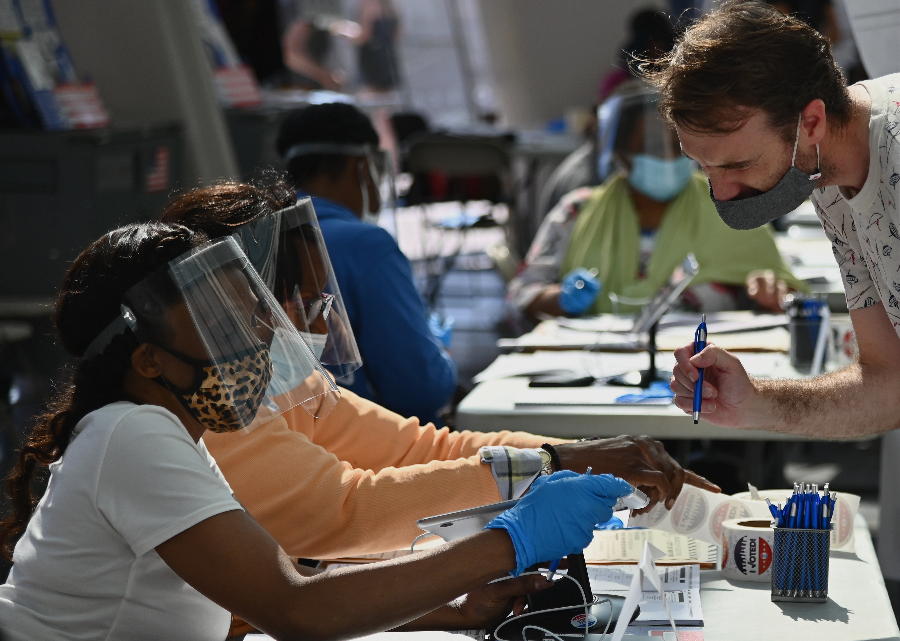 Board of Election employees and volunteers wearing PPE (personal protective equipment) assist voters during the New York Democratic presidential primary elections on June 23, 2020 in New York City. (Photo by Angela Weiss / AFP) (Photo by ANGELA WEISS/AFP via Getty Images)