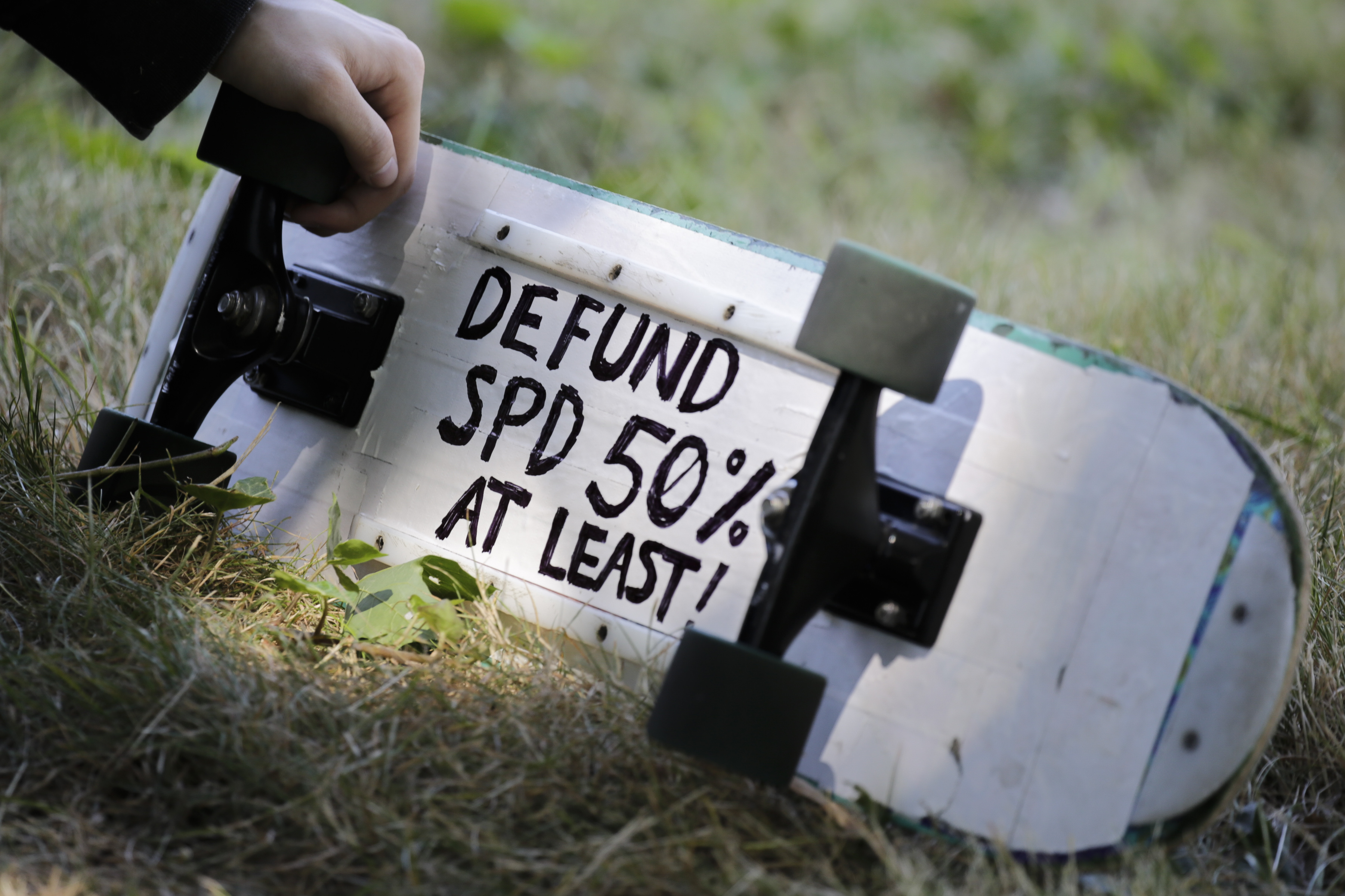 A defund Seattle Police Department (SPD) sign is pictured on a protester's skateboard during a "Defund the Police" march from King County Youth Jail to City Hall in Seattle, Washington on August 5, 2020. (Photo by Jason Redmond / AFP) (Photo by JASON REDMOND/AFP via Getty Images)