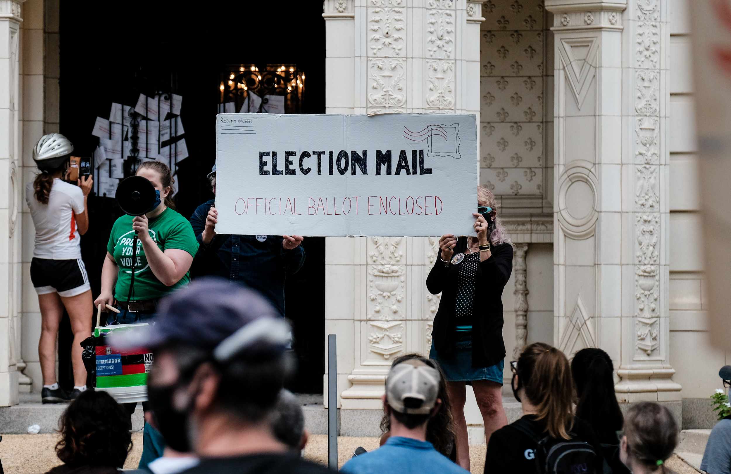 WASHINGTON, DC - AUGUST 15: Demonstrators gather outside of the condo of President Donald Trump donor and current U.S. Postmaster General Louis Dejoy on August 15, 2020 in Washington, DC. The protests are in response to a recent statement by President Trump to withhold USPS funding that would ensure that the post office would be unable handle mail-in voting ballots for the upcoming 2020 Election. (Photo by Michael A. McCoy/Getty Images)