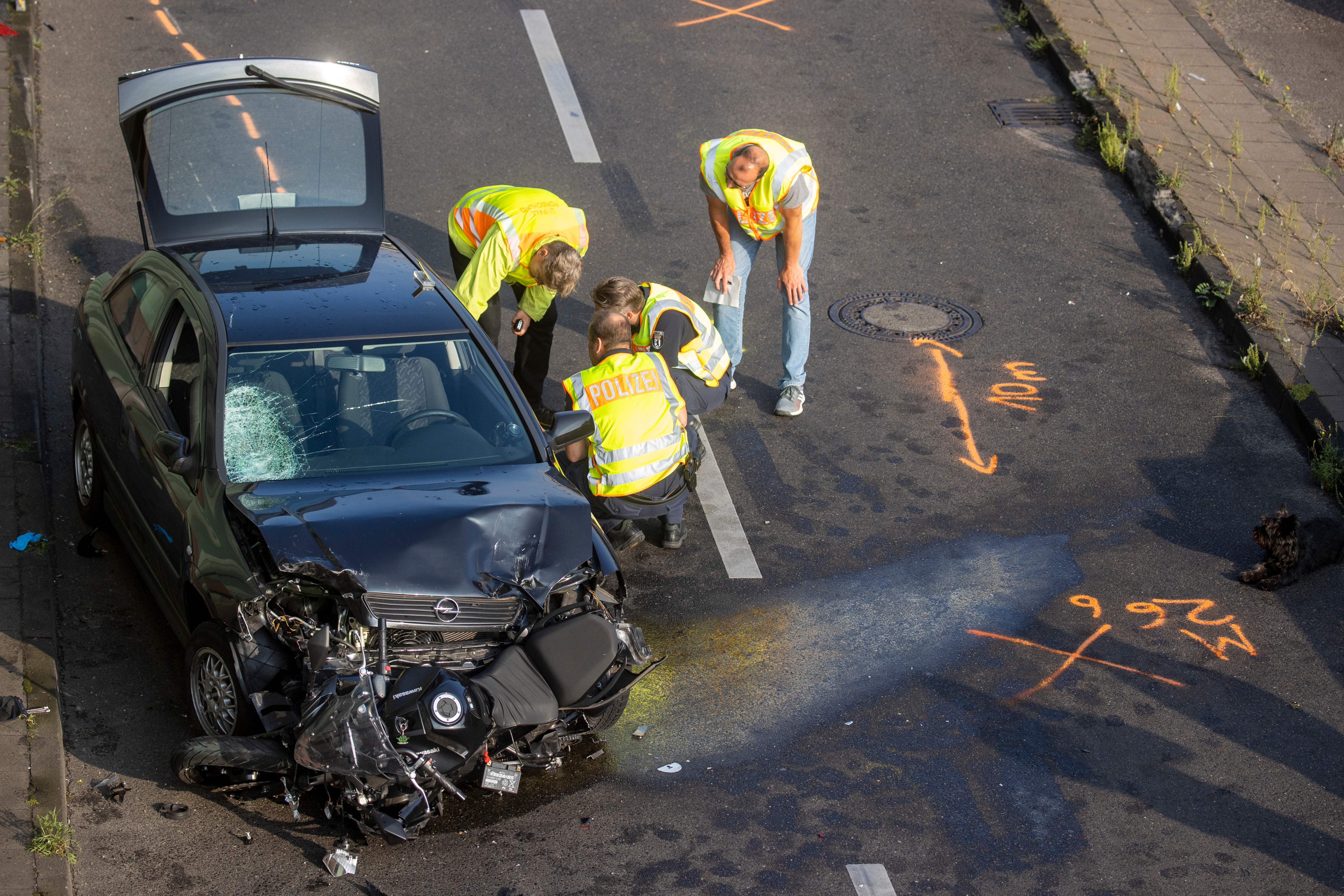 Police officers and forensic experts secure evidences at the site where a motorcycle crashed with a car, probably the car used by an alleged offender to cause several accidents on the A 100 highway in Berlin on August 19, 2020.(Photo by ODD ANDERSEN/AFP via Getty Images)