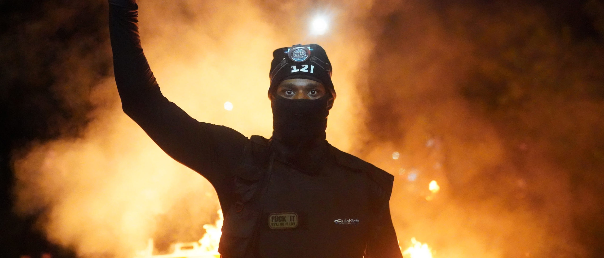 PORTLAND, OR - AUGUST 23: A protester holds his fist in the air during a protest against racial injustice and police brutality early in the morning on August 23, 2020 in Portland, Oregon. Hundreds of protesters clashed with police Saturday night following a rally in east Portland. (Photo by Nathan Howard/Getty Images)