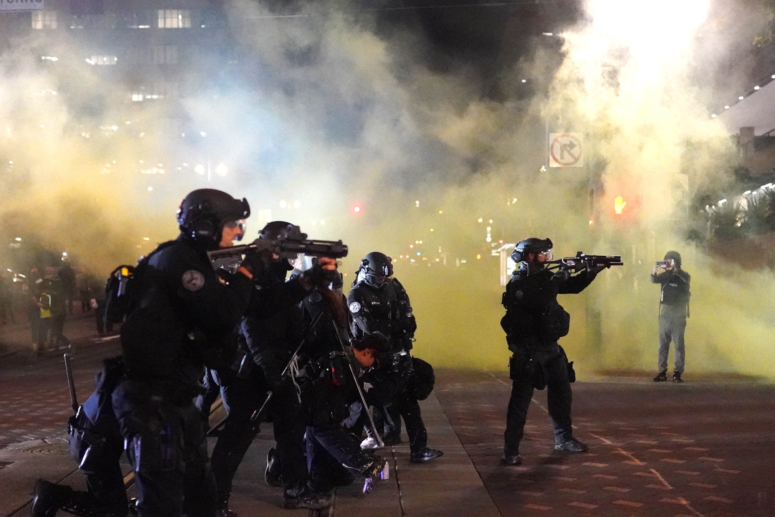 PORTLAND, OR - AUGUST 25: Portland police officers fires less lethal rounds through smoke while dispersing a crowd of about 150 people from Portland City Hall on August 25, 2020 in Portland, Oregon. Crowds chanted in support of Kenosha Wisconsin on the 90th night of protests Tuesday, where demonstrations have continued for days following the police shooting of Jacob Blake. (Photo by Nathan Howard/Getty Images)