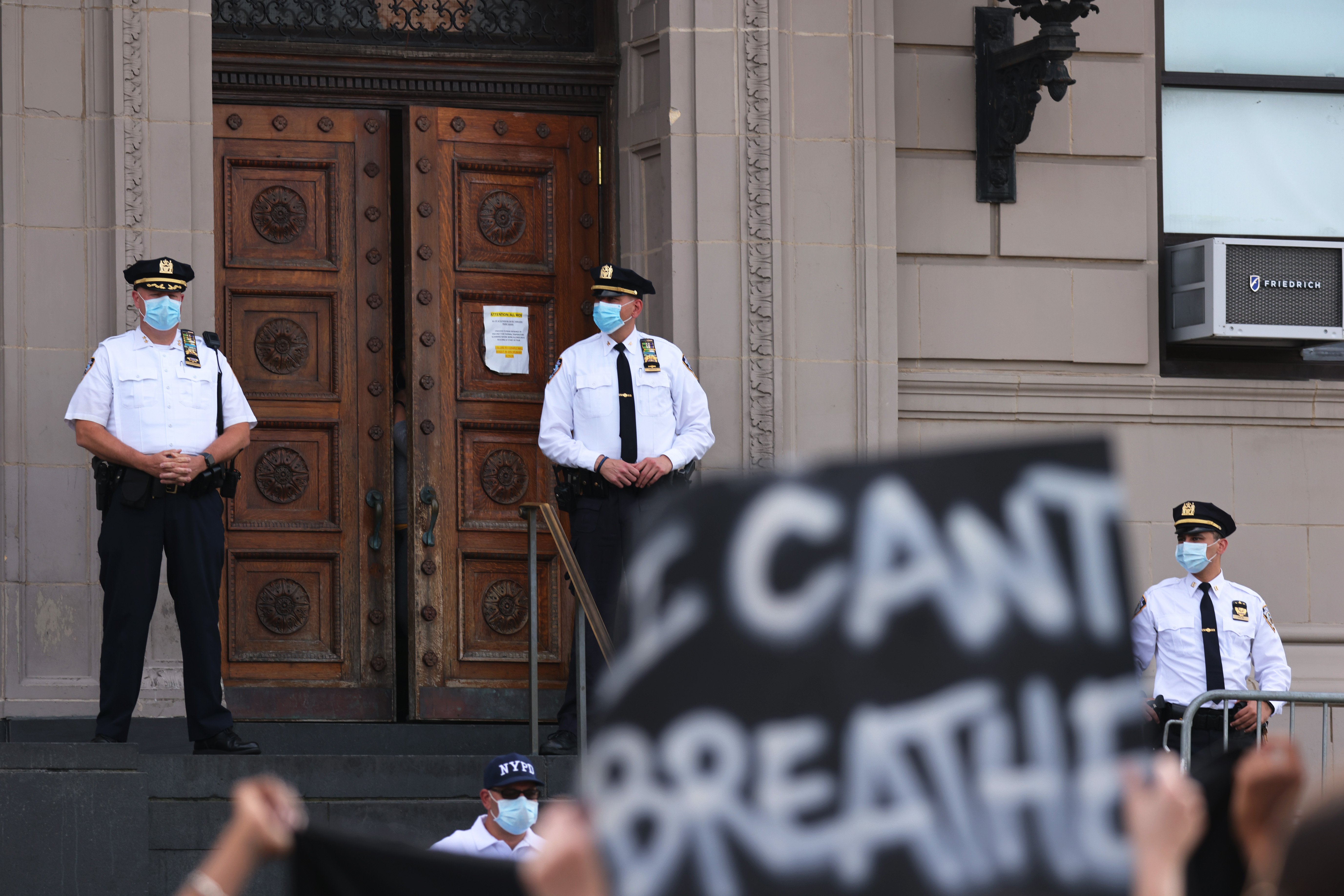 Police officers stand guard as protesters gather in front of the 120th NYPD precinct on the sixth anniversary of Eric Garner's death in Tompkinsville, Staten Island on July 17, 2020 in New York City. (Michael M. Santiago/Getty Images)