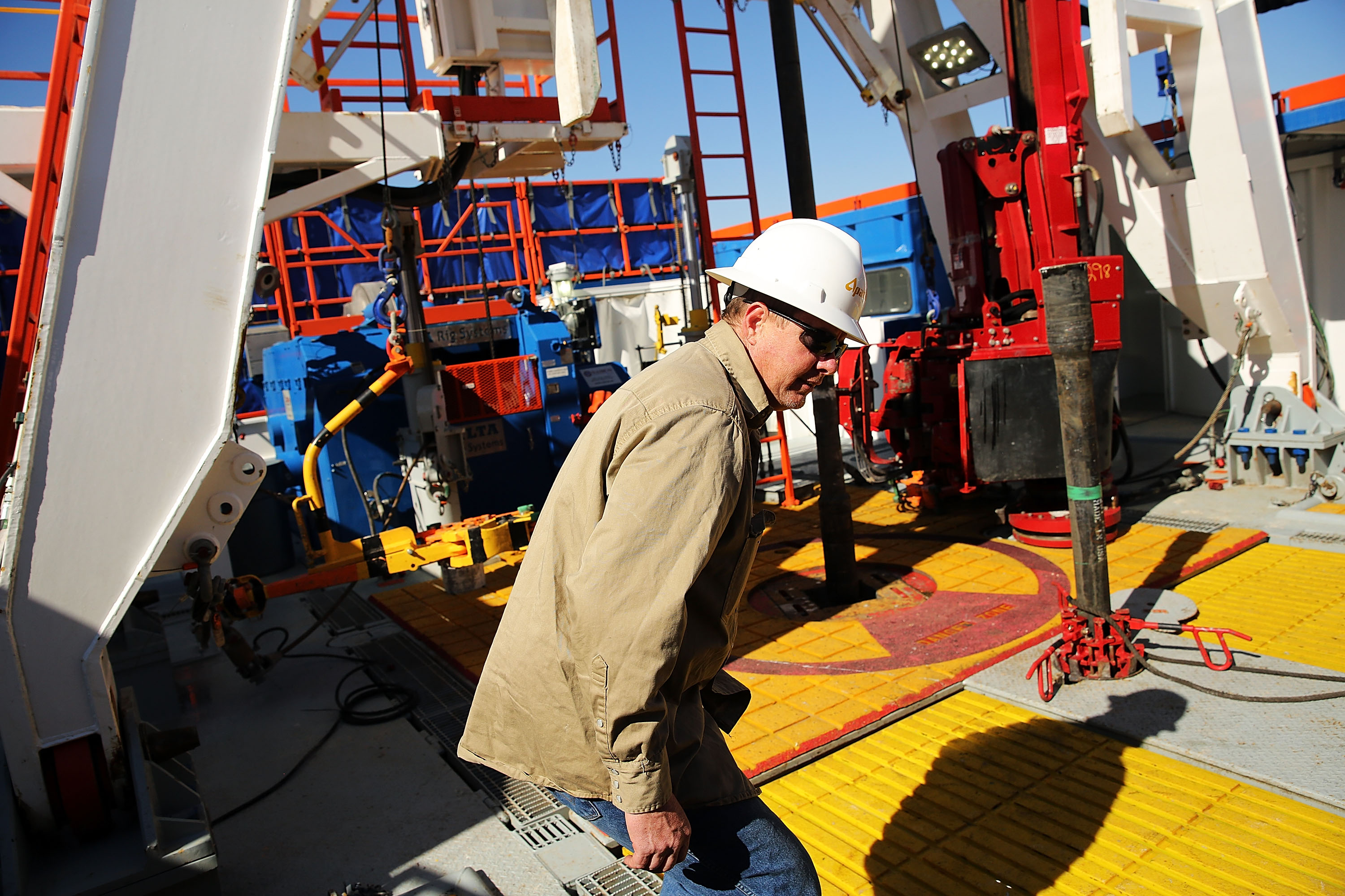 A worker with Apache Corp. is viewed at the Patterson 298 natural gas fueled drilling rig on land in the Permian Basin in 2015 in Mentone, Texas. (Spencer Platt/Getty Images)
