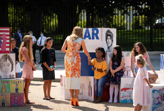 First Lady Melania Trump shakes hands with a girl as she tours an art exhibit during an event with young artists who depicted imagery related to the suffrage movement and the 19th Amendment, at the White House in Washington, U.S., August 24, 2020. REUTERS/Al Drago