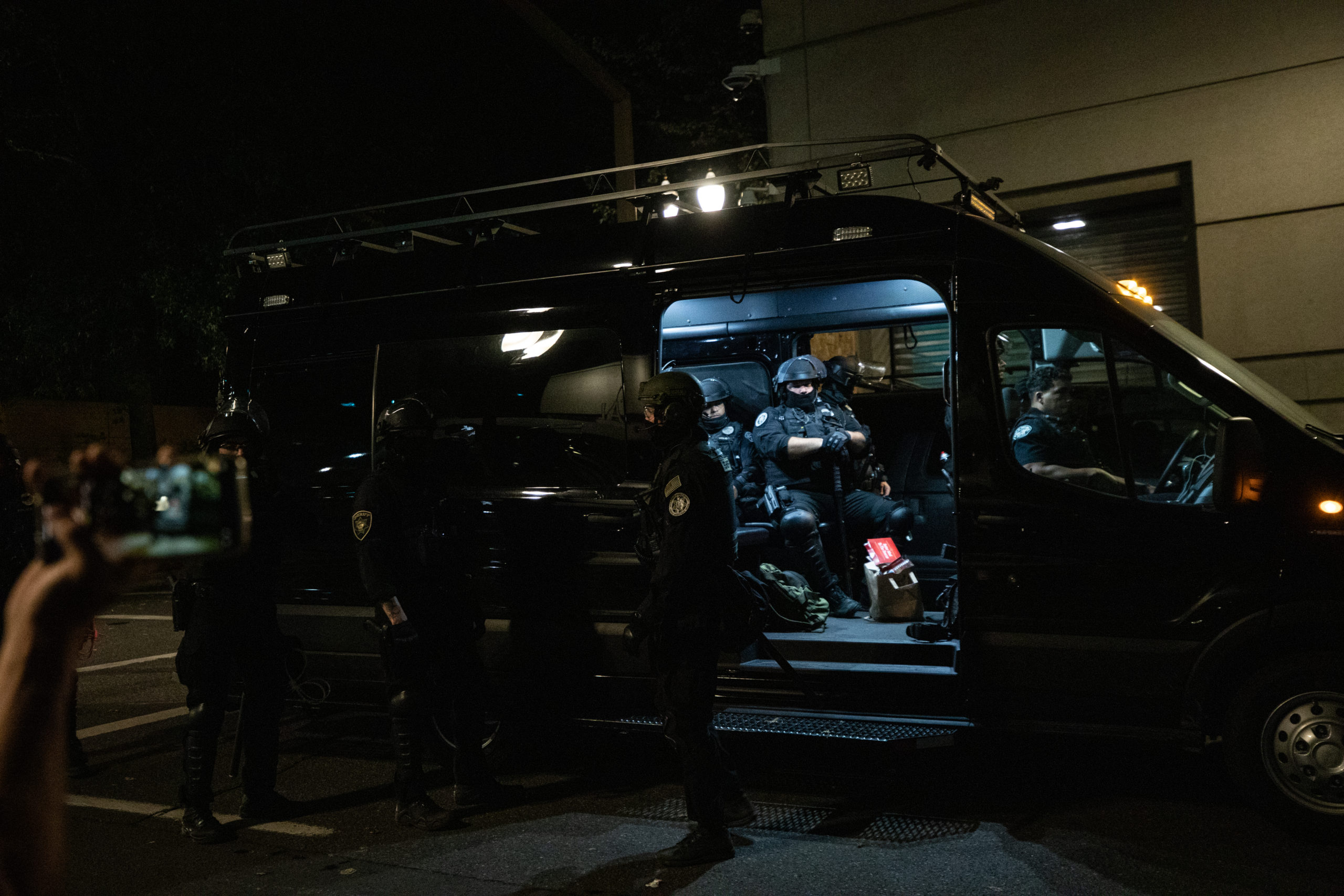 Police gather into an unmarked van outside of the Portland Police Bureau in Portland, Oregon, on Sept. 27, 2020. (Photo: Kaylee Greenlee / DCNF) 