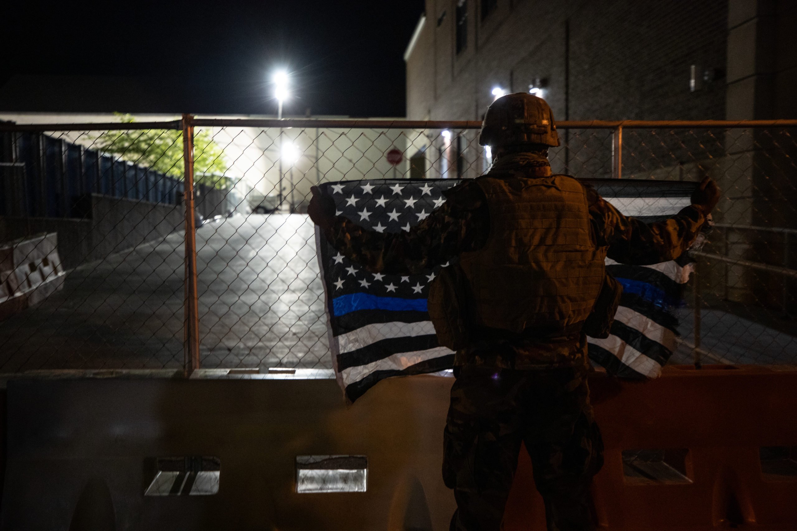 A man dressed in camouflage held a Thin Blue Line flag outside the Lancaster Bureau of Police Building, where officers were stationed. (Photo - Kaylee Greenlee / Daily Caller News Foundation)