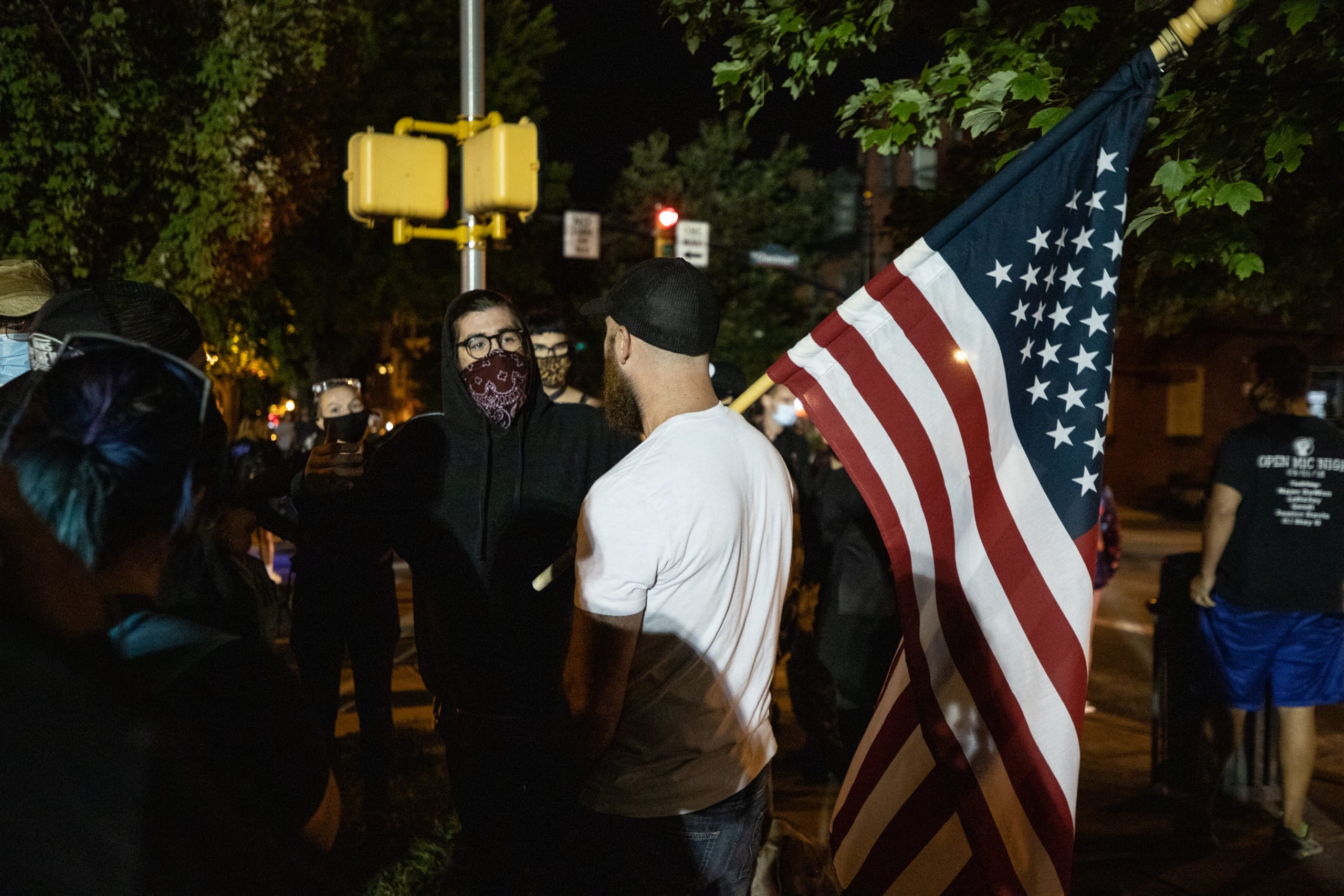 A man with an American flag talked with protesters throughout the night in Lancaster, Philadelphia on Sept. 14, 2020. (Photo - Kaylee Greenlee / Daily Caller News Foundation)