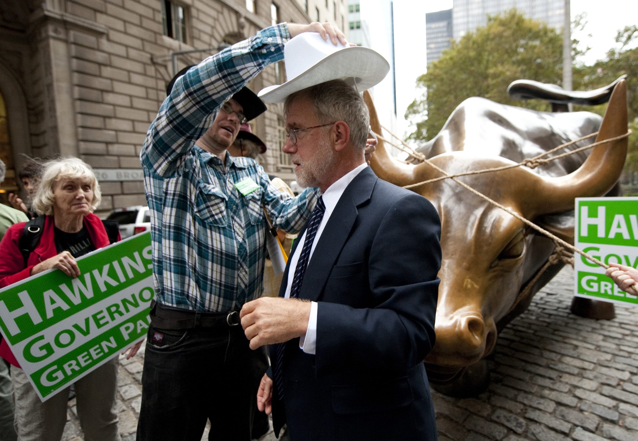 Green Party candidate for NY Governor, Howie Hawkins, has a hat placed on his head by a campaign worker October 27, 2010 at the Bowling Green Bull in New York. At his "Wall Street Rodeo" Hawkins said that stock transfer tax money should be going into jobs not back into Wall Street coffers. AFP PHOTO/DON EMMERT (Photo credit should read DON EMMERT/AFP via Getty Images)
