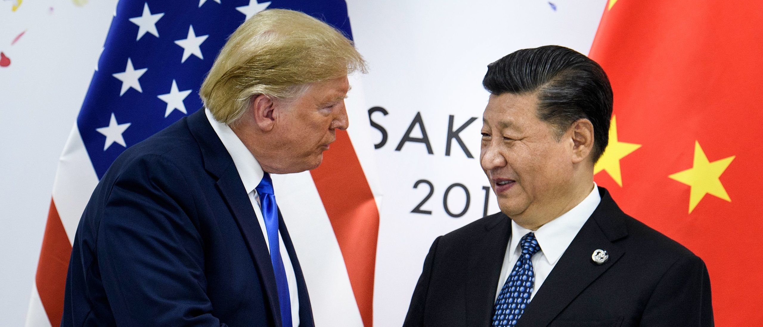 (FILES) In this file photo taken on June 28, 2019, China's President Xi Jinping (R) shakes hands with US President Donald Trump before a bilateral meeting on the sidelines of the G20 Summit in Osaka. - From the Arab Spring to bloodletting in Syria, from Obama to Trump, from terror in the streets of Paris to Brexit, the 2010s began with hope for a more equitable world, and end with a slide towards nationalistic populism. (Photo by BRENDAN SMIALOWSKI/AFP via Getty Images)