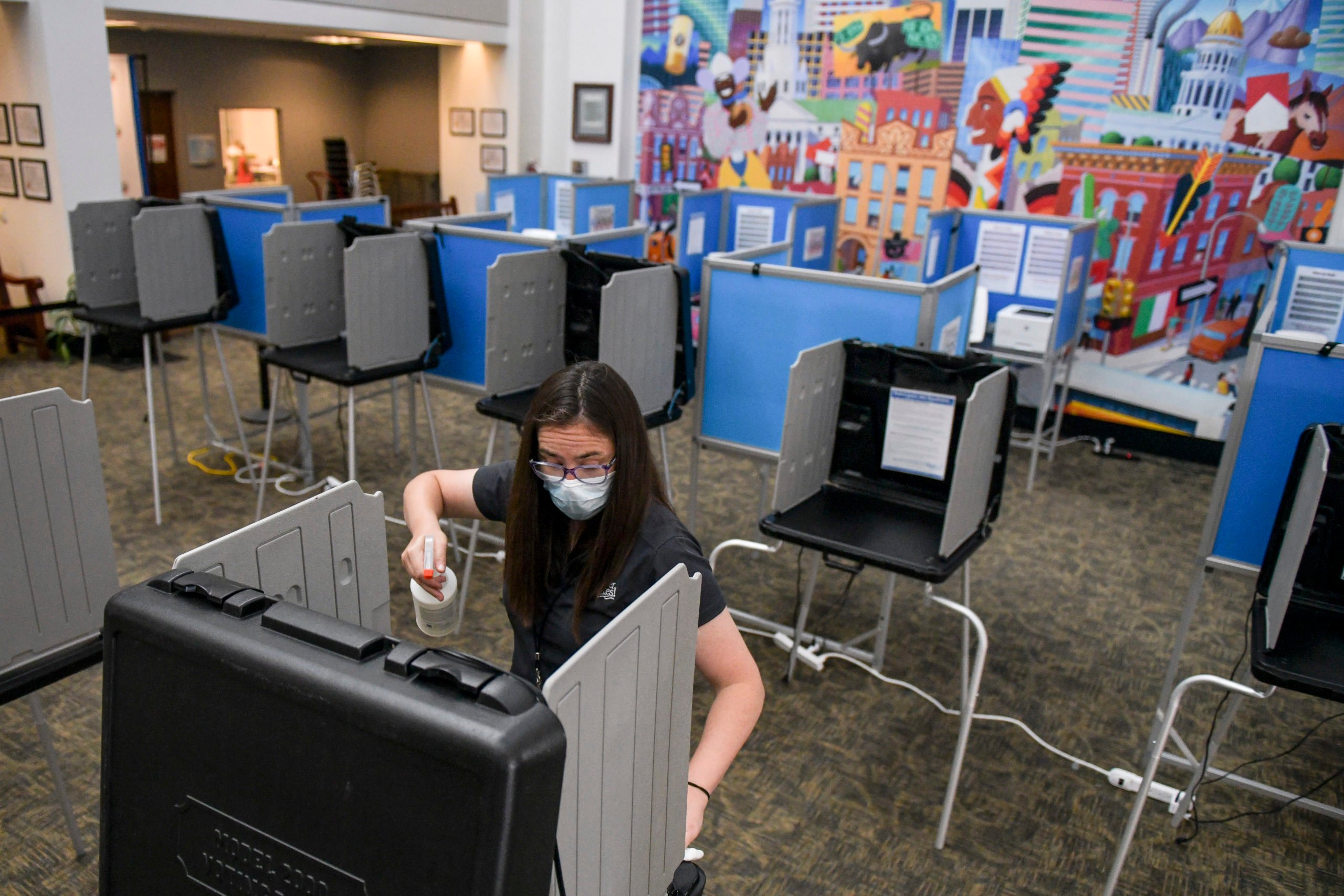 DENVER, CO - JUNE 30: Election judge Miriam Dubinsky sanitizes a voting booth as people vote in the primary election on June 30, 2020 in Denver, Colorado. Voters will decide between former Gov. John Hickenlooper and former Colorado House of Representatives Speaker Andrew Romanoff to face off in the November U.S. Senate race against Sen. Cory Gardner. (Photo by Michael Ciaglo/Getty Images)