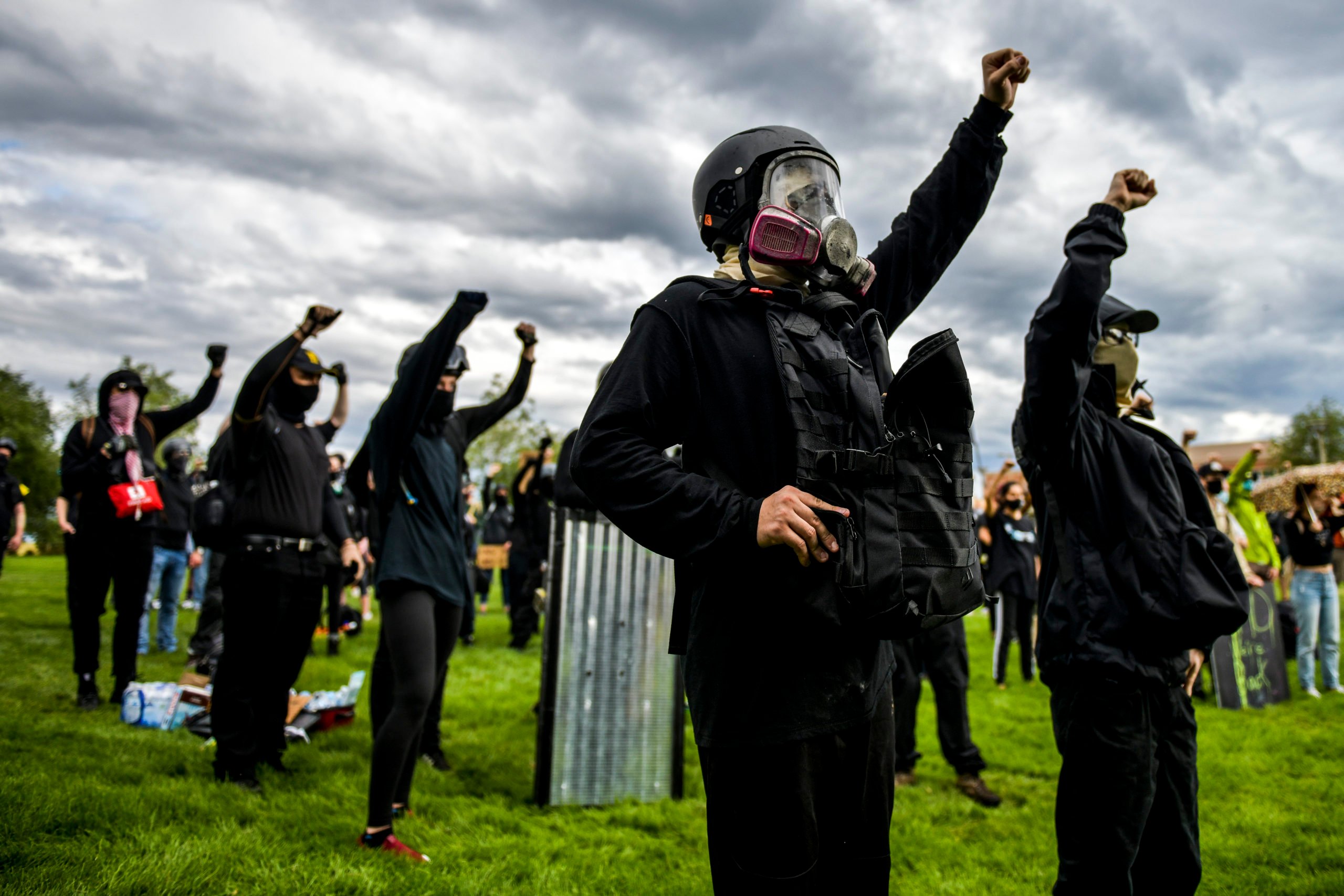 AURORA, CO - JULY 25: People raise their fists in the air as they protest the death of Elijah McClain outside the Aurora Police Department Headquarters on July 25, 2020 in Aurora, Colorado. On August 24, 2019 McClain was walking home when he was forcibly detained by three Aurora police officers and was injected with ketamine after officers requested assistance from the Aurora Fire Rescue. McClain suffered a heart attack on the way to the hospital that night and died six days later. (Michael Ciaglo/Getty Images)