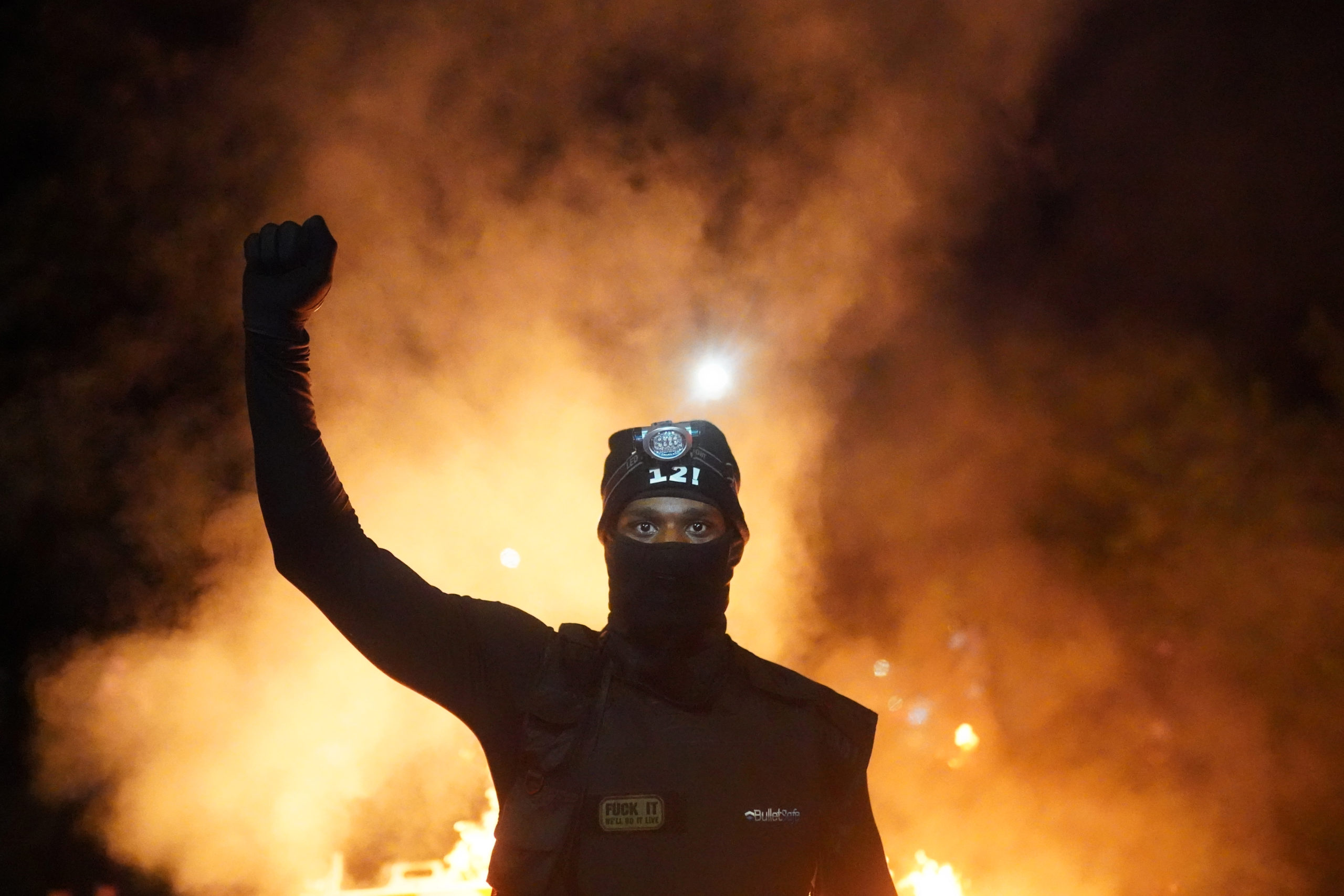 PORTLAND, OR - AUGUST 23: A protester holds his fist in the air during a protest against racial injustice and police brutality early in the morning on August 23, 2020 in Portland, Oregon. Hundreds of protesters clashed with police Saturday night following a rally in east Portland. (Photo by Nathan Howard/Getty Images)
