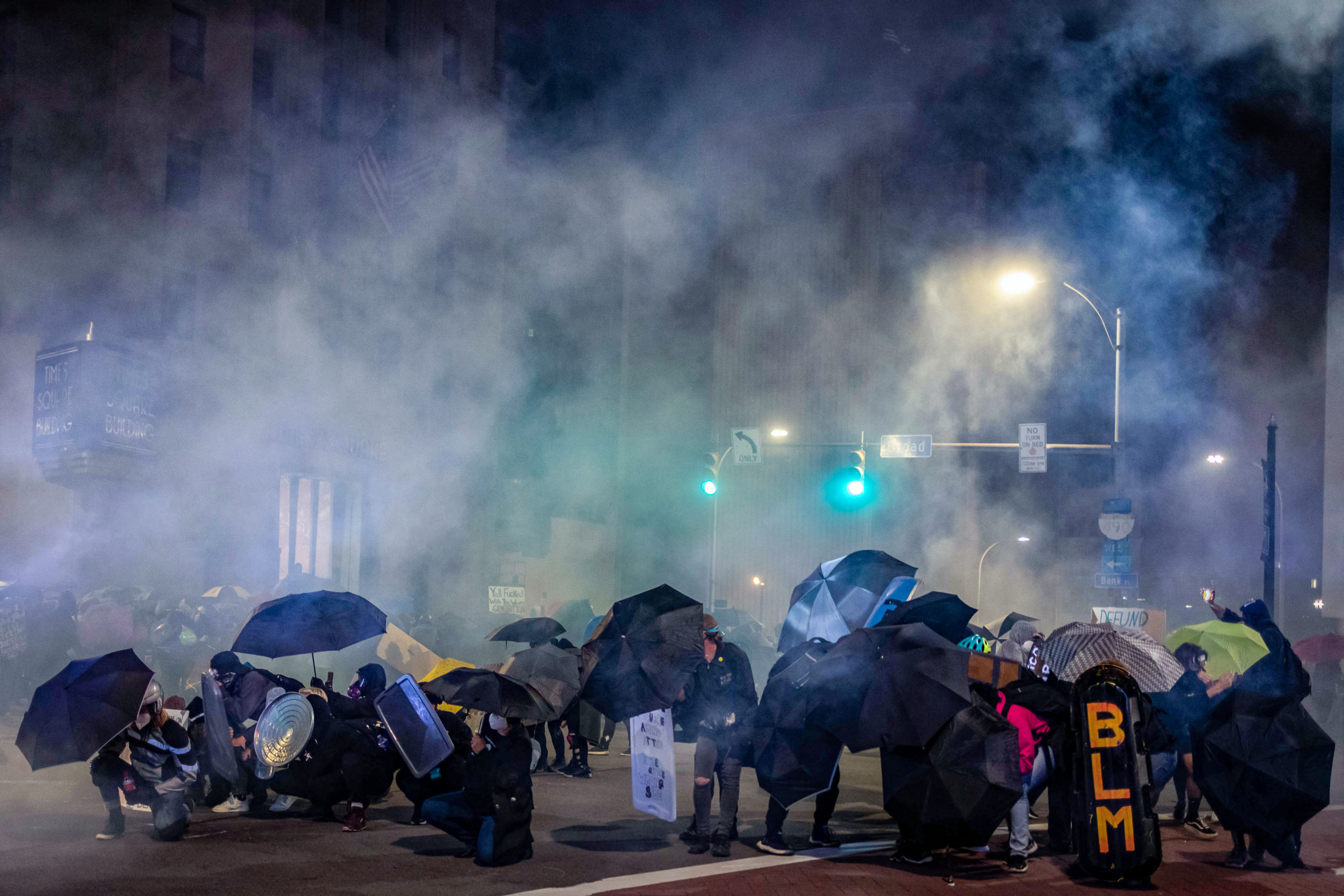 TOPSHOT - Protesters use umbrellas and homemade shields in an attempt to protect themselves from pepper,"less-lethal" munitions and teargas in Rochester, New York, on September 5, 2020, on the fourth night of protest following the release of video showing the death of Daniel Prude. - Prude, a 41-year-old African American who had mental health issues, died of asphyxiation after police arrested him on March 23, 2020, in Rochester. (Photo by Maranie R. STAAB / AFP) (Photo by MARANIE R. STAAB/AFP via Getty Images)