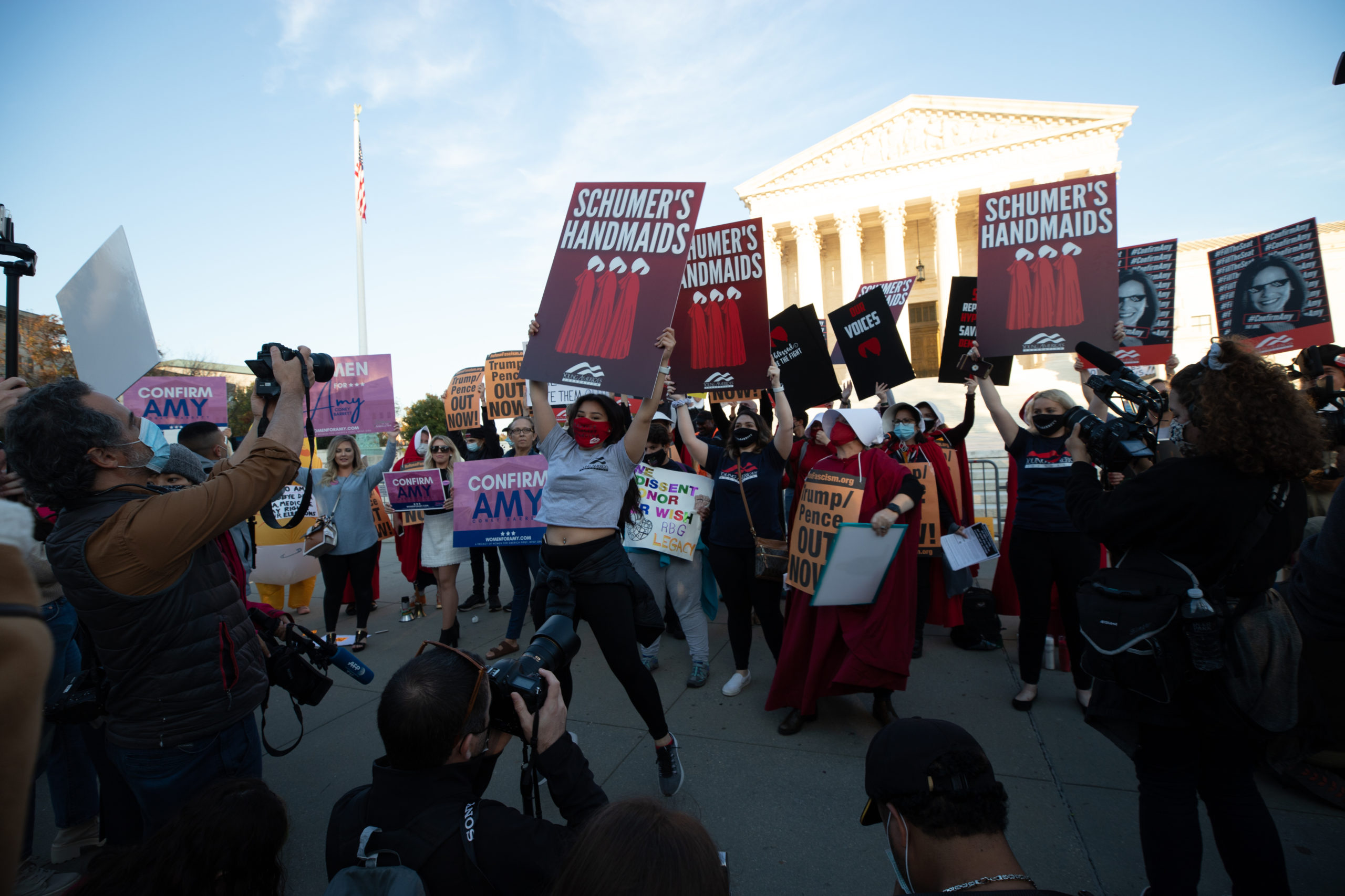 A woman with Young America's Foundation jumps in front of anti-Amy Coney Barrett and anti-Trump protesters at the Supreme Court in Washington, D.C. on October 26, 2020. (Kaylee Greenlee - Daily Caller News Foundation)