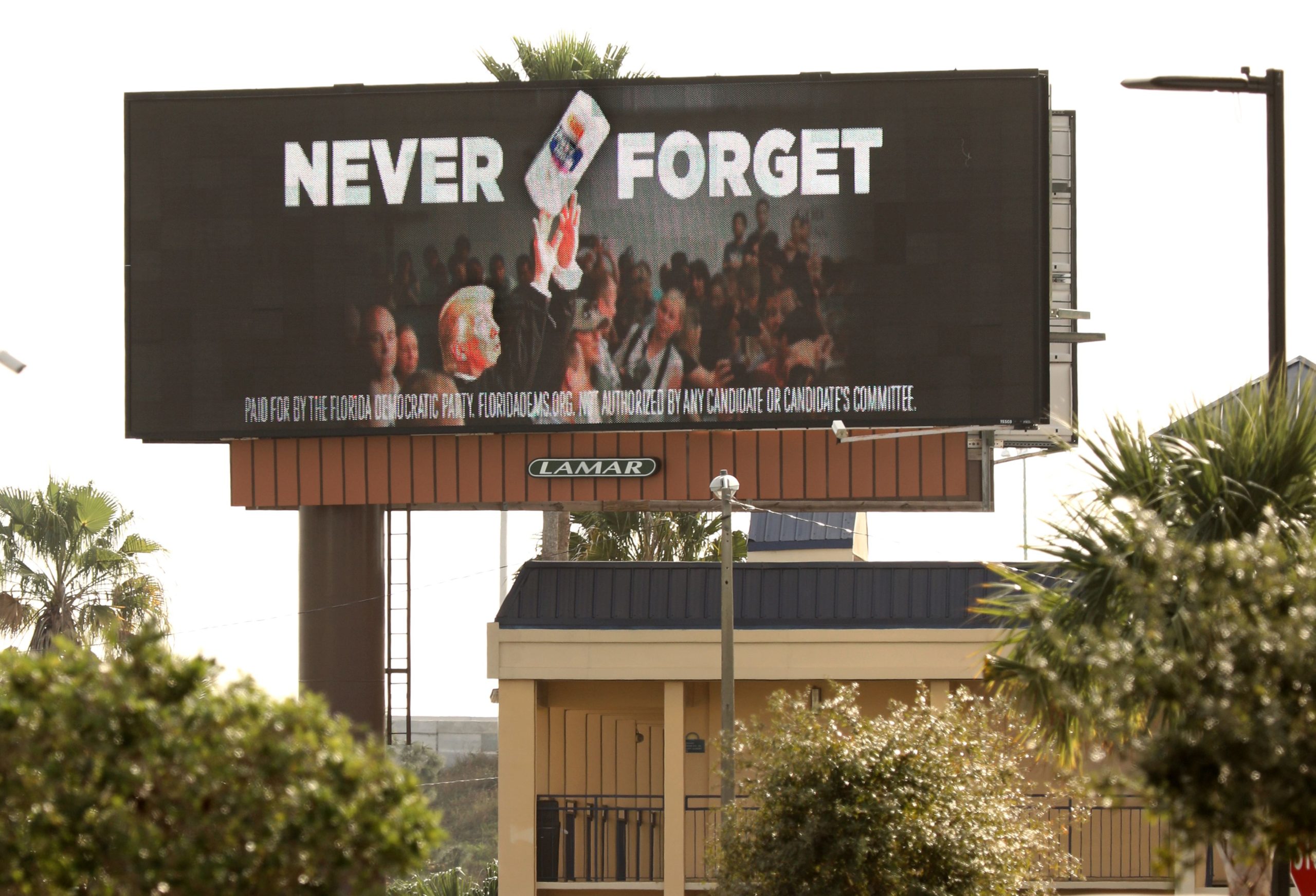 An electronic billboard advertisement paid for by the Florida Democratic Party reading "Never Forget" and showing US President Donald Trump throwing a roll of paper towels is seen along the Florida Turnpike in Kissimmee, Florida, on January 16, 2020. - It shows US President Donald Trump throwing a roll of paper towels to a crowd awaiting aid in Puerto Rico in the aftermath of Hurricane Maria in October of 2017. Some 3,000 people were killed in the natural disaster and many Puerto Rican citizens relocated to central Florida afterward. The billboard ads, in both Spanish and English, are aimed at Latino and Hispanic voters in Florida, which are a significant portion of the state's population. (Photo by Gregg Newton / AFP) (Photo by GREGG NEWTON/AFP via Getty Images)