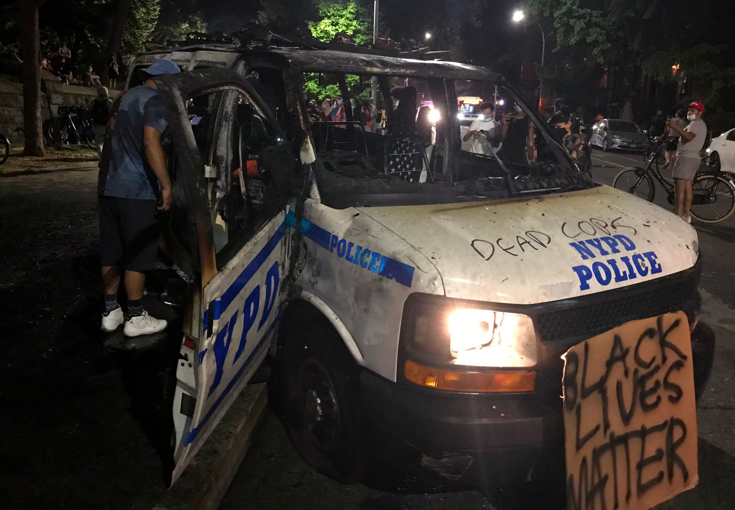 The remains of a scorched police vehicle lie vandalized during riots in the Fort Greene neighborhood in the Brooklyn borough of New York on May 29, 2020. - The woman who threw the molotov cocktail inside the vehicle occupied by four officers on the fringes of a demonstration in New York on Friday was arrested, the New York Police Department told AFP on May 30, 2020, the Brooklyn Museum. The 27-year-old woman threw the molotov cocktail at the back window of the van, which broke under, a spokeswoman said, but the four officers had time to get out of the vehicle without injury. (THOMAS URBAIN/AFP via Getty Images)