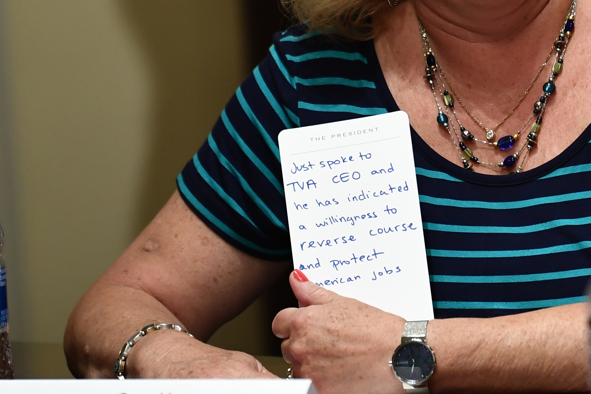 Gay Henson, President of Engineering Association, Tennessee Valley Authority holds a note card as US President Donald Trump speaks, before signing an Executive Order on Hiring American at the White House on Aug. 3. (Brendan Smialowski/AFP via Getty Images)