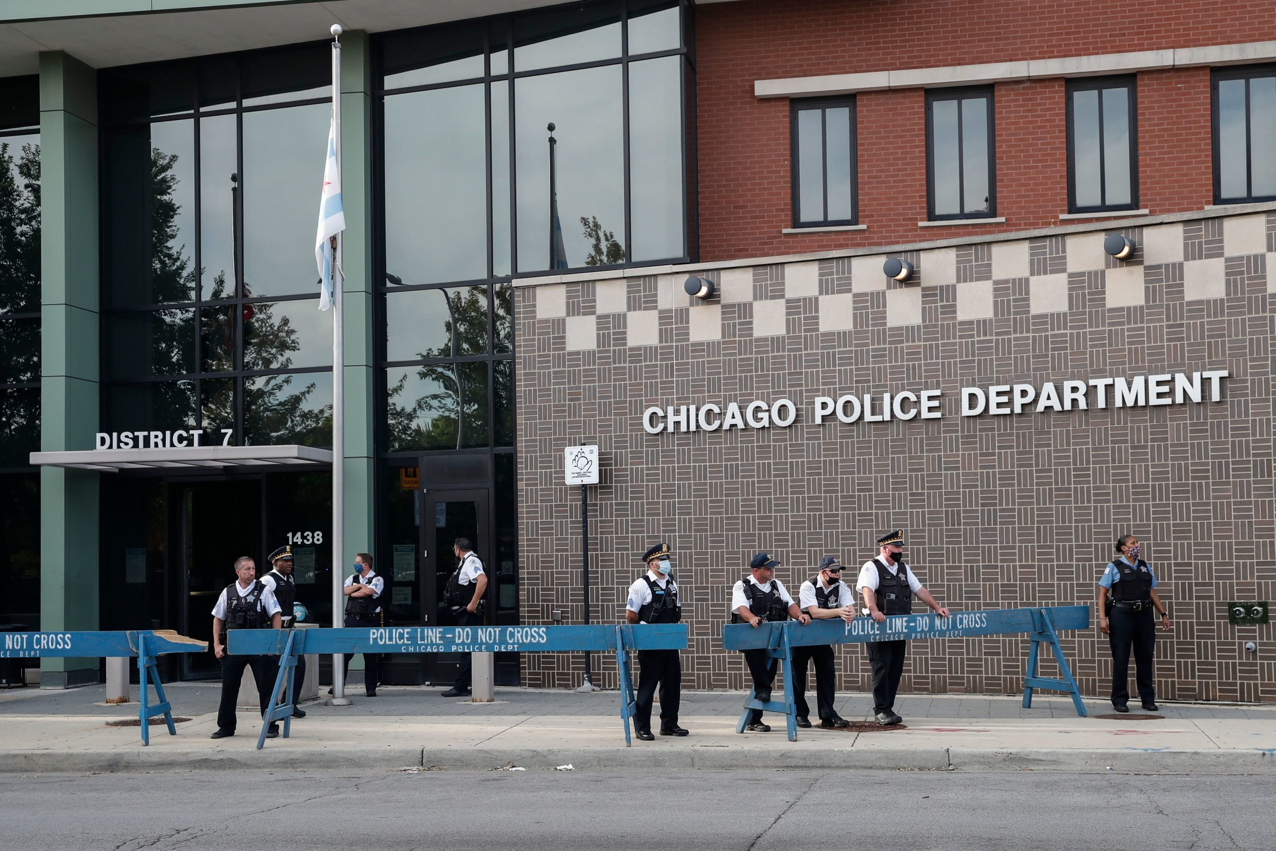 Chicago Police officers monitor the area outside their District 7 headquarters during a rally against Chicago Police violence in the Englewood neighborhood in Chicago, Illinois, on August 11, 2020. (Photo by KAMIL KRZACZYNSKI / AFP) (Photo by KAMIL KRZACZYNSKI/AFP via Getty Images)