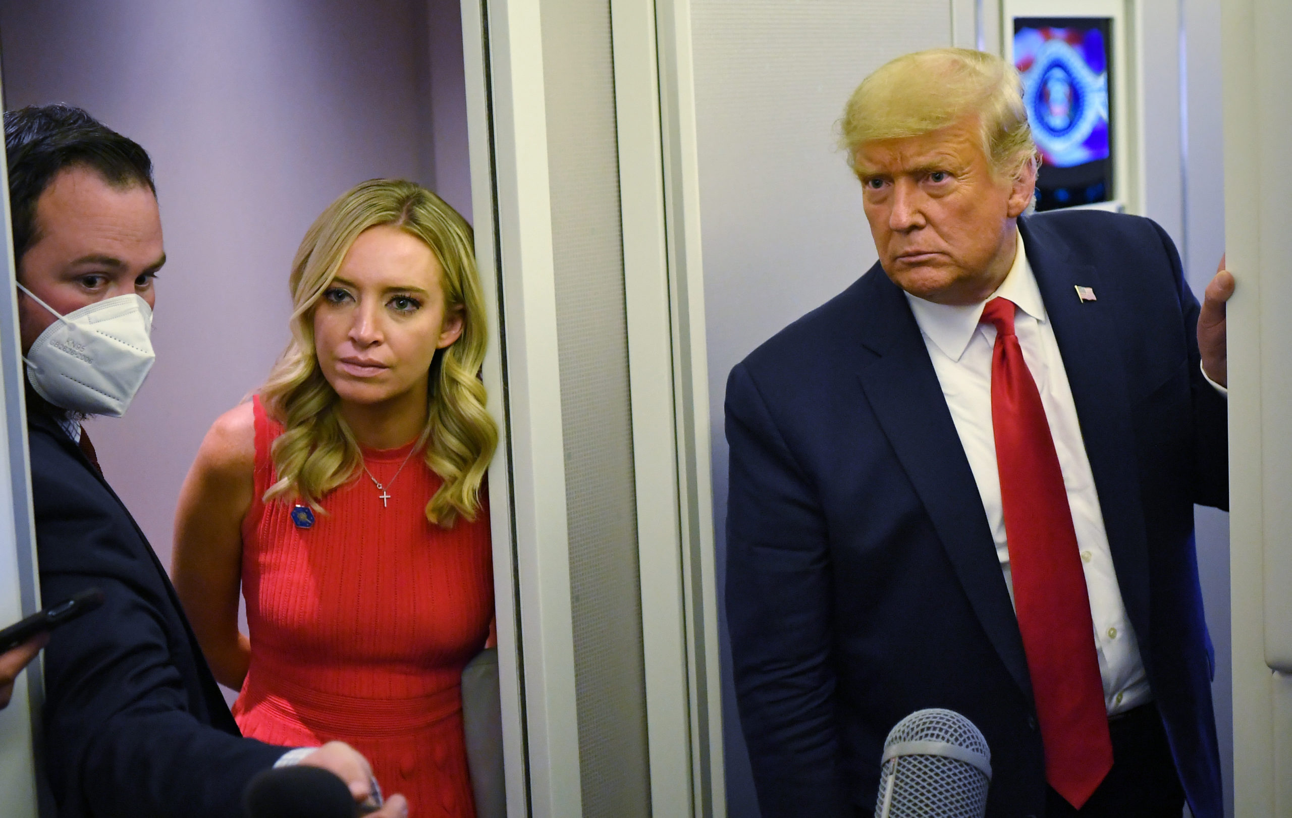 US President Donald Trump, flanked by White House Press Secretary Kayleigh McEnany (L), speaks reporters while in flight aboard Air Force One shortly before landing at Andrews Air Force Base in Maryland on October 19, 2020. (Photo by MANDEL NGAN/AFP via Getty Images)