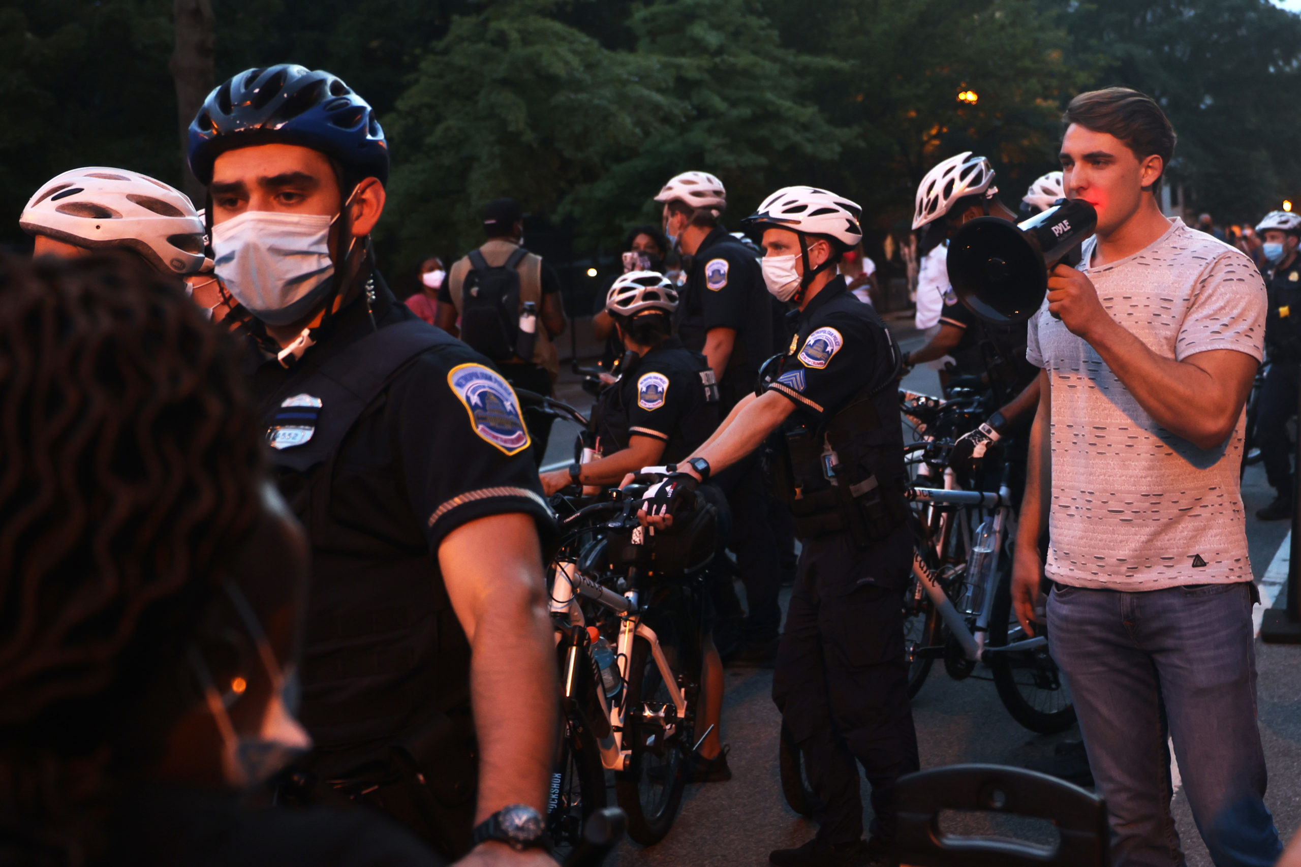 WASHINGTON, DC - AUGUST 27: Police officers surround Jacob Wohl as he taunts protesters during a "Trump/Pence Out Now" rally at Black Lives Matter plaza August 27, 2020 in Washington, DC. Protesters gathered as the Republican National Convention on its final night was set to nominate President Donald Trump for a second term in office. (Photo by Michael M. Santiago/Getty Images)