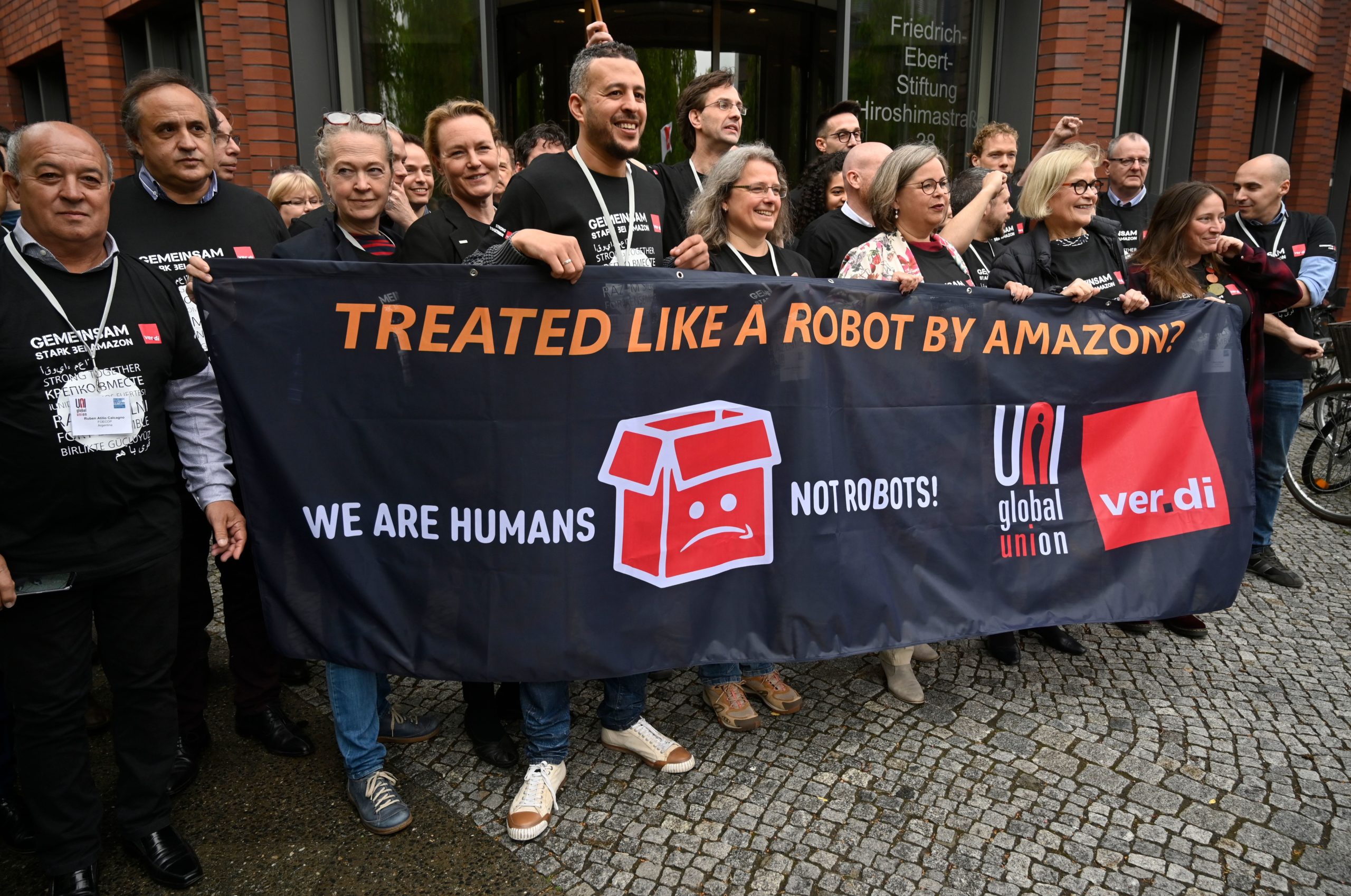 Representatives of Amazon workers hold a banner reading "We are Humans not robots!" as they demonstrate on April 29, 2019 in front of the headquarters of the Friedrich-Ebert Foundation in Berlin, where an international union meeting was held with the participation of German service workers' union verdi and the UNI global union. (John MacDougall/AFP via Getty Images)