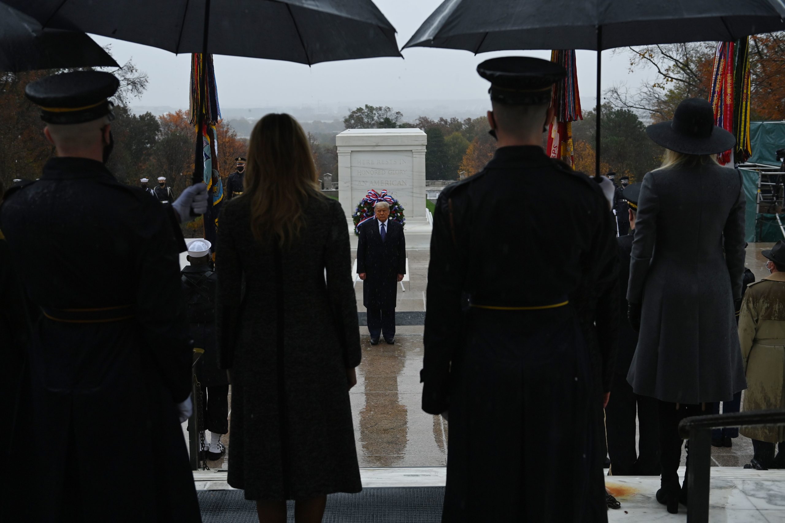 US President Donald Trump(C) attends a "National Day of Observance" wreath laying ceremony on November 11, 2020 at Arlington National Cemetery in Arlington, Virginia. - US President Donald Trump made his first official post-election appearance Wednesday for what should be a moment of national unity to mark Veteran's Day, now marred by his refusal to acknowledge Joe Biden's win. The president visited Arlington National Cemetery, four days after US media projected his Democratic rival would take the White House. (Photo by BRENDAN SMIALOWSKI/AFP via Getty Images)