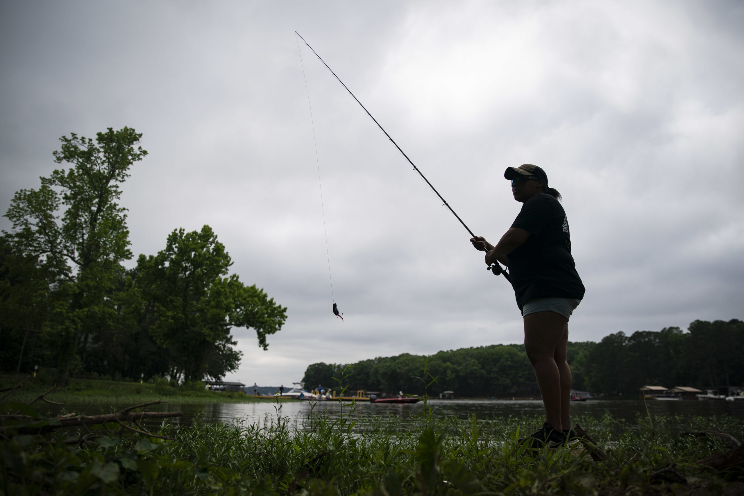 MOUNT GILEAD, NC - MAY 25: A woman fishes on Lake Tillery near the Lilly's Bridge Marina on Memorial Day, May 25, 2020 in Mount Gilead, North Carolina. Despite overcast skies, locals did not miss an opportunity to head outdoors on the first weekend of the state's Phase 2 reopening during the ongoing coronavirus pandemic. (Photo by Al Drago/Getty Images)