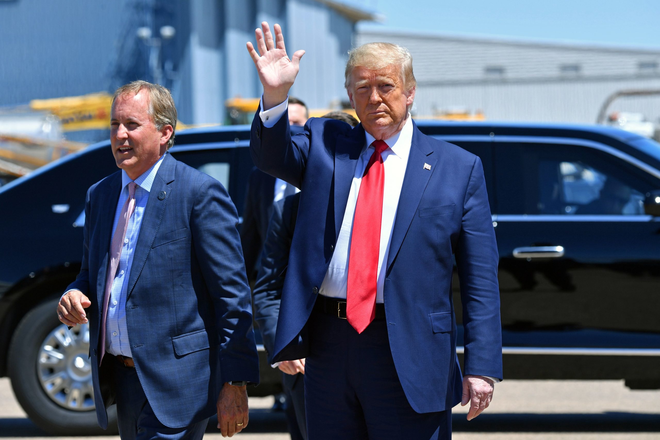 US President Donald Trump waves upon arrival, alongside Attorney General of Texas Ken Paxton (L) in Dallas, Texas, on June 11, 2020, where he will host a roundtable with faith leaders and small business owners. (Photo by Nicholas Kamm / AFP) (Photo by NICHOLAS KAMM/AFP via Getty Images)