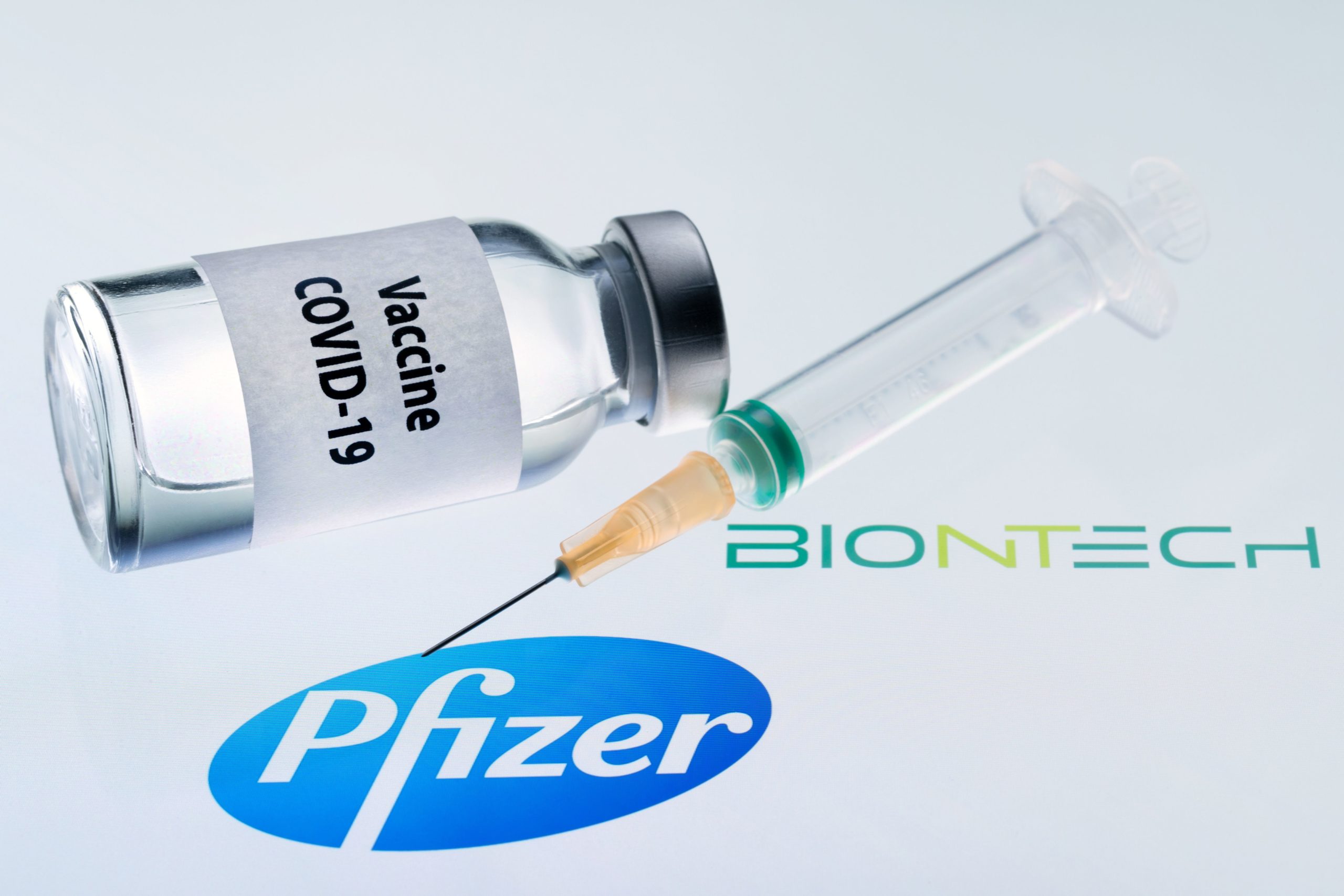 This illustration picture taken on November 23, 2020 shows a bottle reading "Vaccine Covid-19" and a syringe next to the Pfizer and Biontech logo. - The European Commission has signed five contracts to pre-order vaccines, among which with the U.S.-German company Pfizer-BioNTech (up to 300 million doses). (JOEL SAGET/AFP via Getty Images)