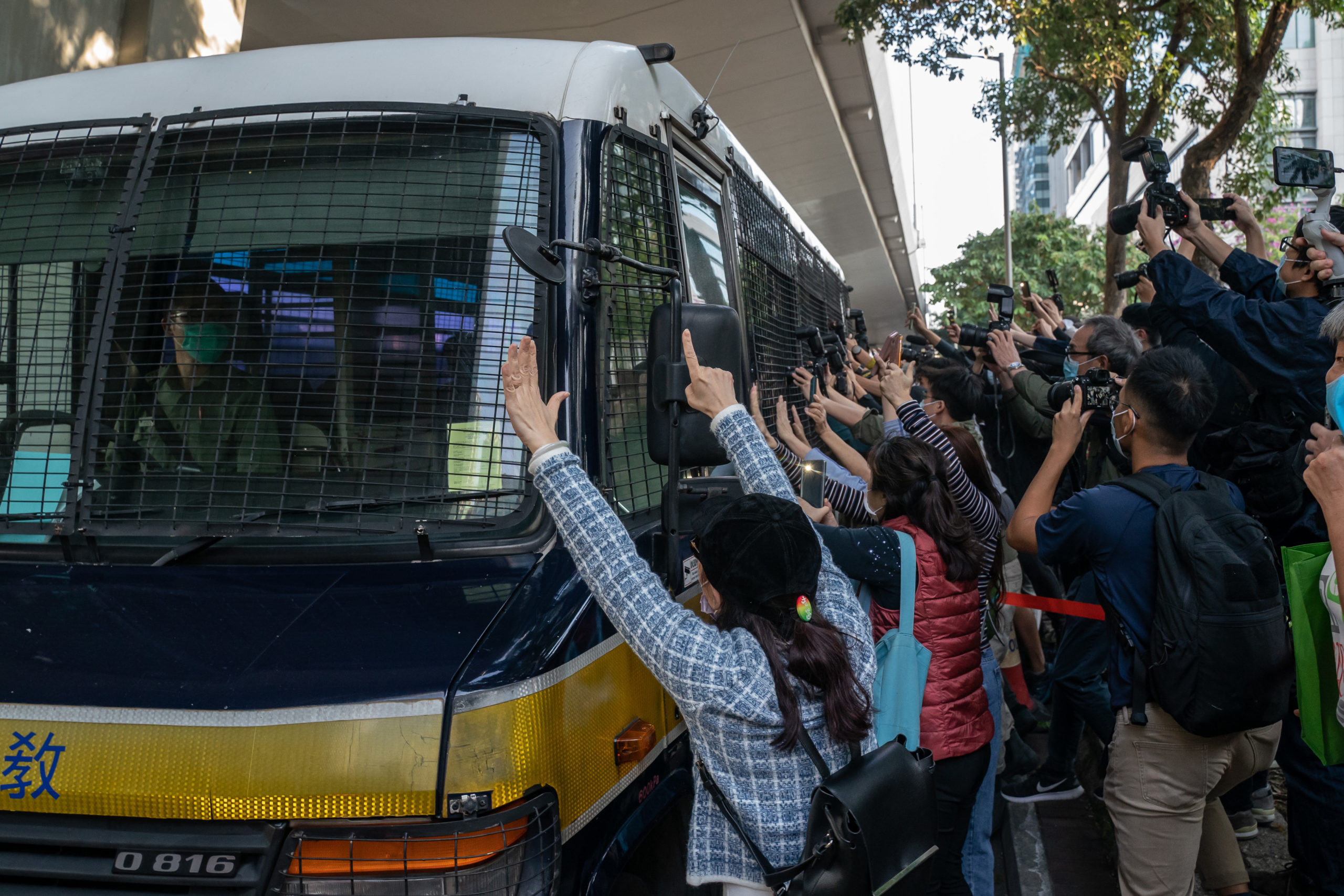 Supporters react as a Correctional Services Department vehicle leaves court after pro-democracy activists Joshua Wong, Agnes Chow and Ivan Lam were sentenced on Wednesday in Hong Kong. (Anthony Kwan/Getty Images)