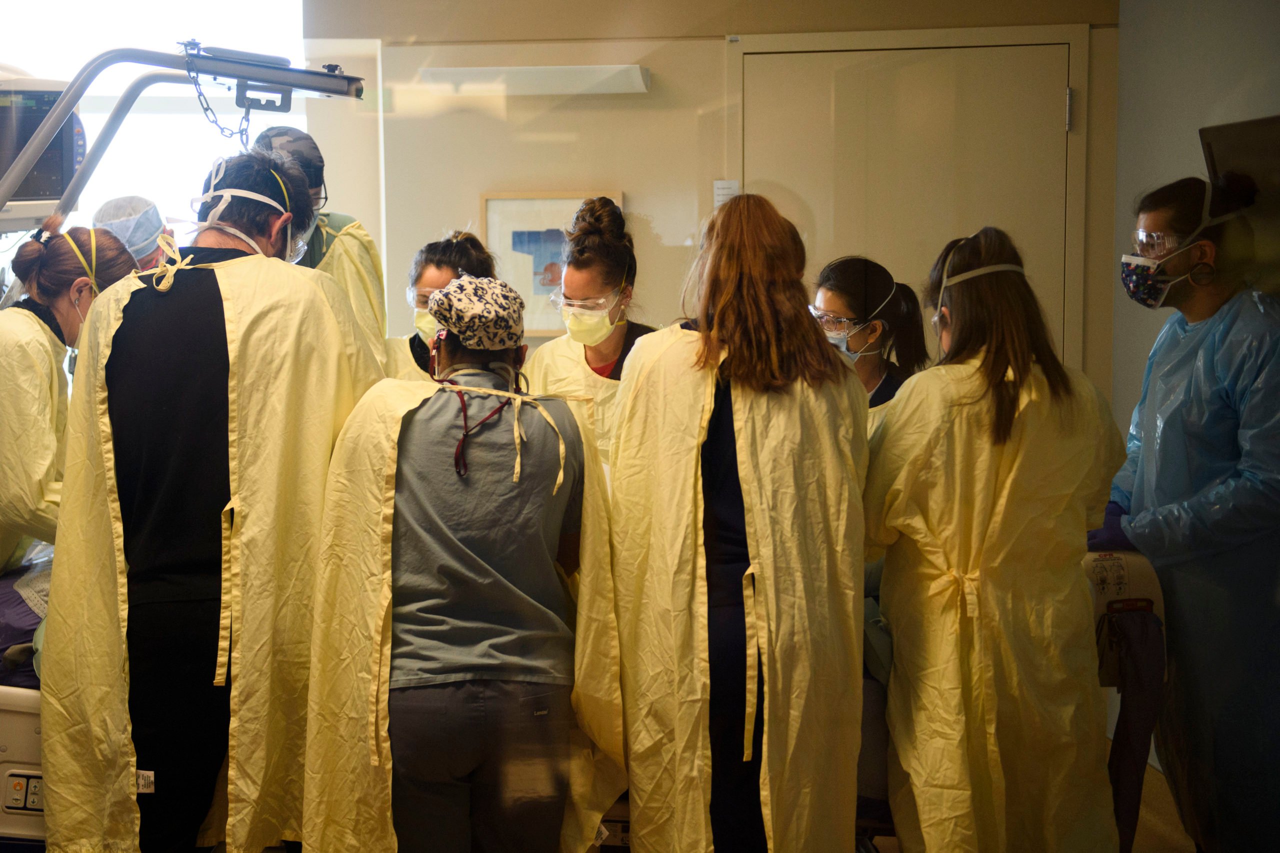 A team of health care workers including physicians, nurses, certified nursing assistants, and respiratory specialists wear personal protective equipment (PPE) while turning a patient from their stomach onto their back in the Covid-19 intensive care unit (ICU) at Renown Regional Medical Center on December 16, 2020 in Reno, Nevada. - Renown Health converted two floors of a parking garage into an alternative care site for Covid-19 patients to increase hospital capacity amid a surge in cases, allowing other facilities to be used for patients in more serious condition. The site included the addition of flooring, electrical infrastructure, lighting, water, technology, sanitation, and ventilation. President Trump earlier this month retweeted a tweet that described Renown's structure as "the fake Nevada parking garage hospital" due to a lack of patients in the picture taken before the facility opened. The site is for patients that have mild to moderate Covid-19 cases and do not require critical care, with 24 patients currently and 350 patient visits to date. (Photo by Patrick T. Fallon / AFP) (Photo by PATRICK T. FALLON/AFP via Getty Images)