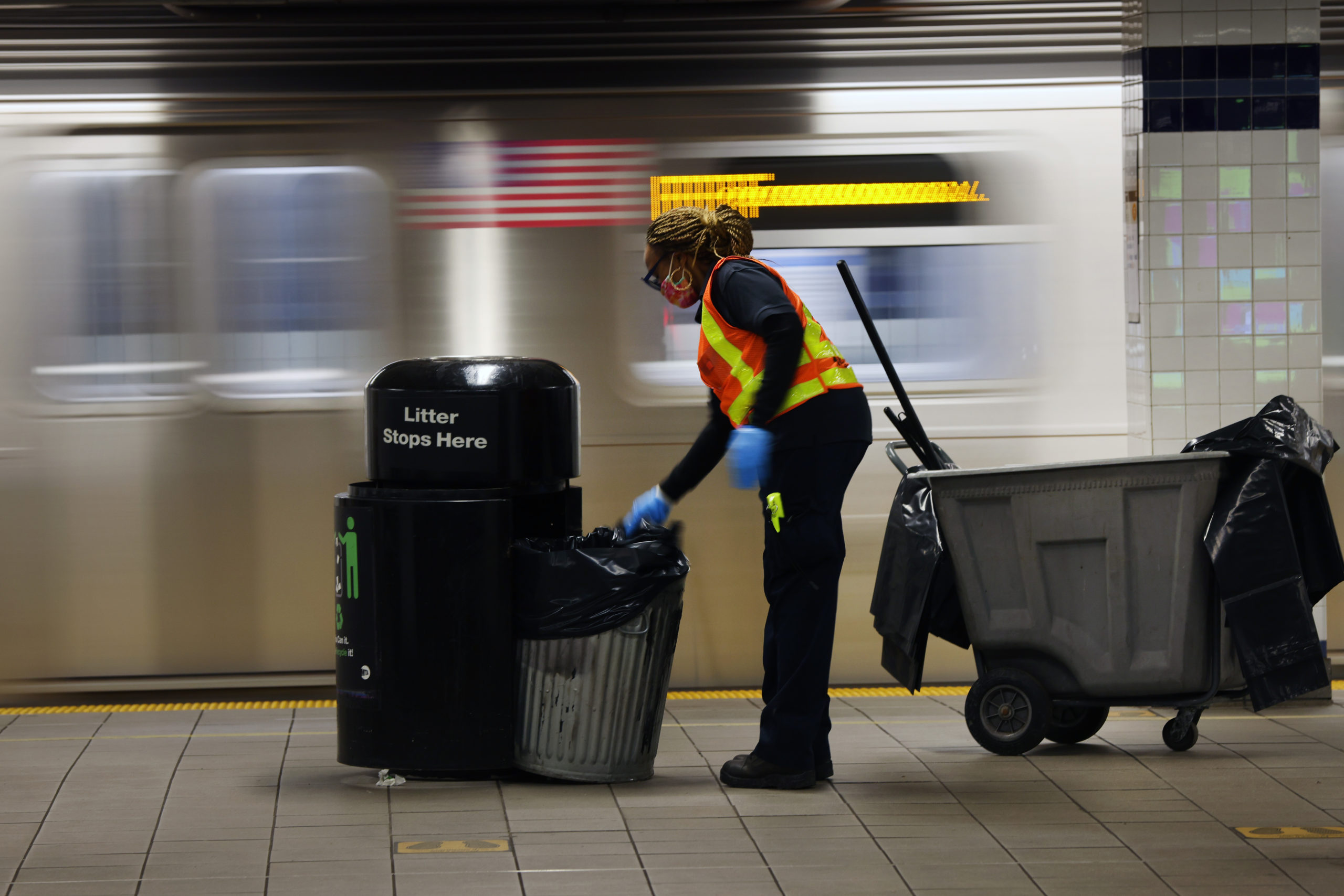 A Metropolitan Transportation Authority worker empties trash at a Brooklyn, New York station on Nov. 18. (Spencer Platt/Getty Images)