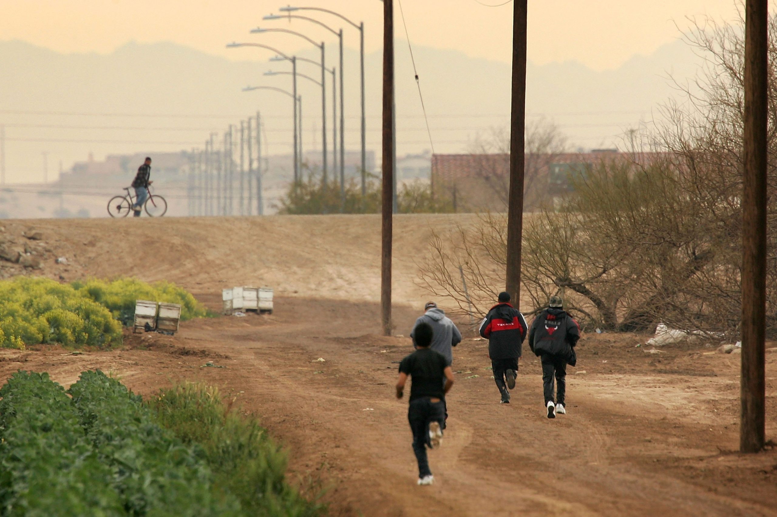 YUMA, AZ - MARCH 16: Men run after crossing illegally into the U.S. from Mexico on March 16, 2006 at the border town of near San Luis, south of Yuma, Arizona. As Congress begins a new battle over immigration policy, U.S. Customs and Border Protection (CBP) border patrol agents in Arizona are struggling to control undocumented immigrants that were pushed into the region by the 1990's border crack-down in California called Operation Gatekeeper. A recent study by the Pew Hispanic Center, using Census Bureau data, estimates that the U.S. currently has an illegal immigrant population of 11.5 million to 12 million, about one-third of them arriving within the past 10 years. More than half are reportedly from Mexico. Ironically, beefed-up border patrols and increased security are reportedly having the unintended result of deterring many from returning to their country of origin. (Photo by David McNew/Getty Images)