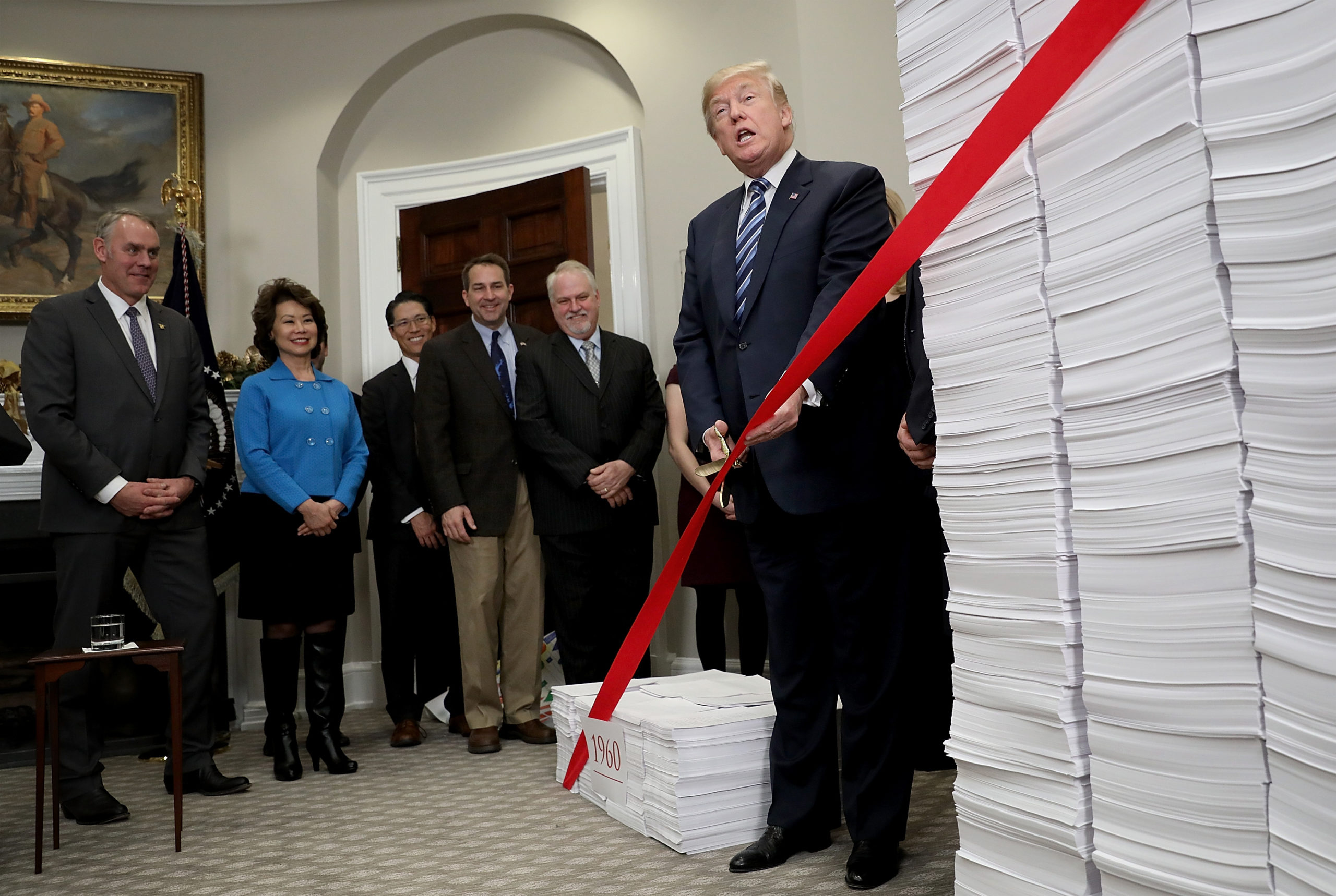 WASHINGTON, DC - DECEMBER 14: U.S. President Donald Trump cuts a symbolic piece of red tape during an event at the White House promoting the administration's efforts to decrease federal regulations December 14, 2017 in Washington, DC. The administration has vowed to remove two regulations for every single regulation added. (Photo by Win McNamee/Getty Images)
