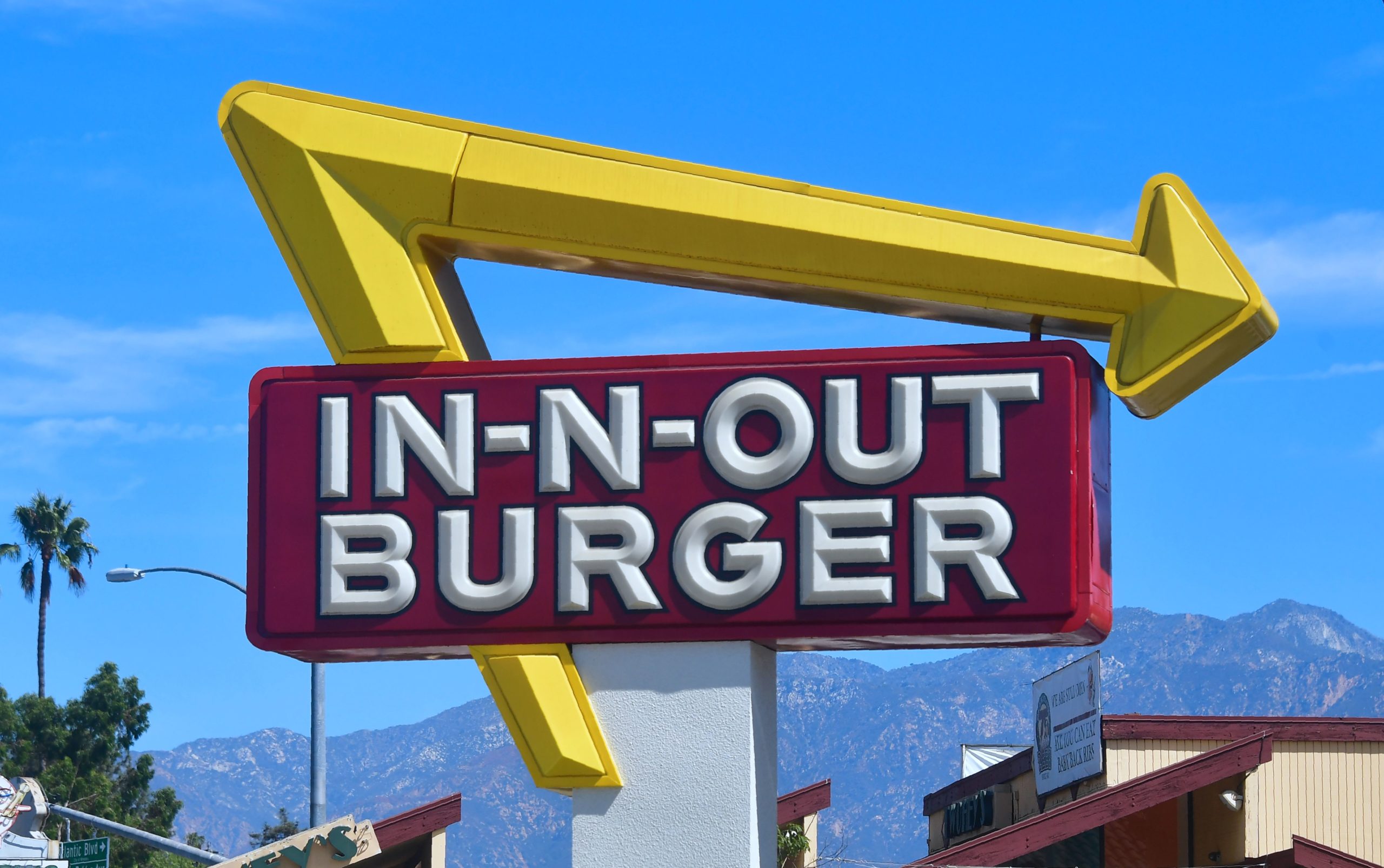 The sign points to an In-N-Out Burger restaurant in Alhambra, California (Photo by FREDERIC J. BROWN/AFP via Getty Images)