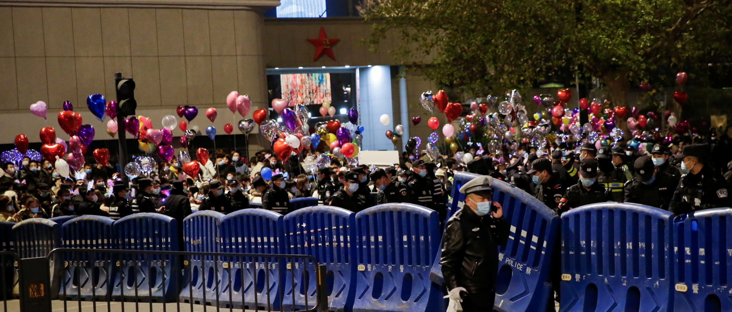 A police officer walks past barriers as people gather to celebrate the arrival of the new year during the coronavirus disease (COVID-19) outbreak in Wuhan, China December 31, 2020. REUTERS/Tingshu Wang