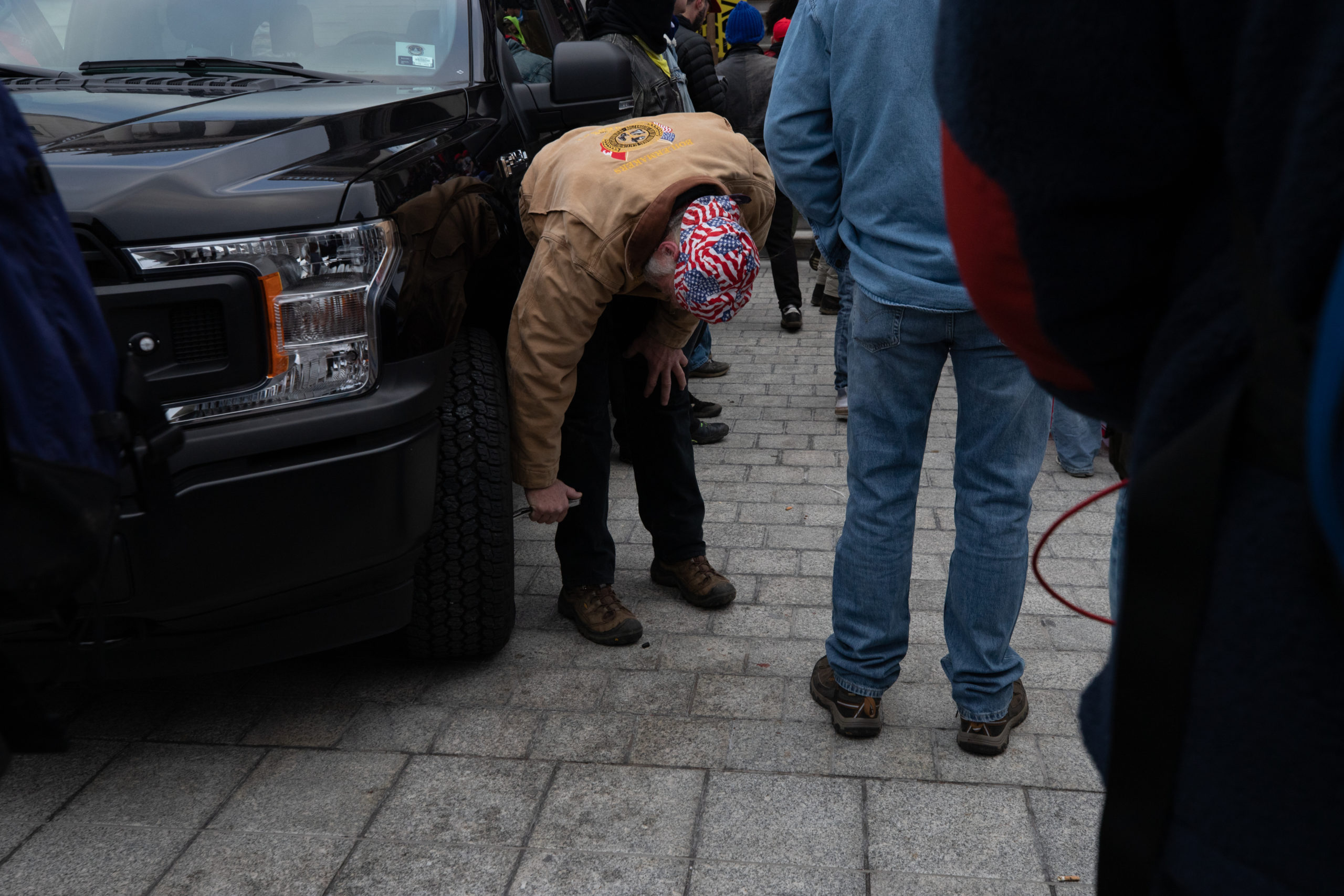 A protester slashed the tires on law enforcement vehicles in Washington, D.C. on Jan. 6, 2021. (Kaylee Greenlee - Daily Caller News Foundation)
