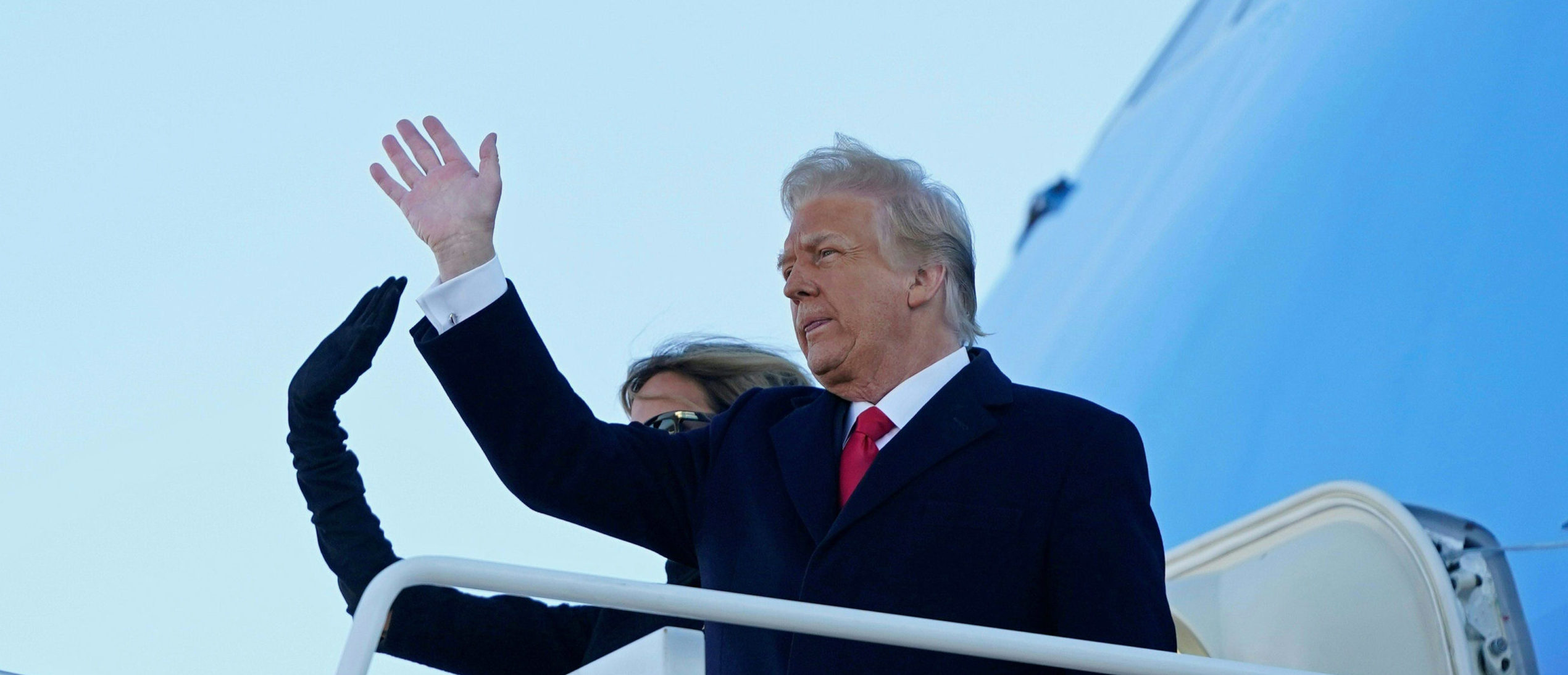 US President Donald Trump and First Lady Melania Trump wave as they board Air Force One at Joint Base Andrews in Maryland on January 20, 2021. - President Trump and the First Lady travel to his Mar-a-Lago golf club residence in Palm Beach, Florida, and will not attend the inauguration for President-elect Joe Biden. (Photo by ALEX EDELMAN / AFP) (Photo by ALEX EDELMAN/AFP via Getty Images)