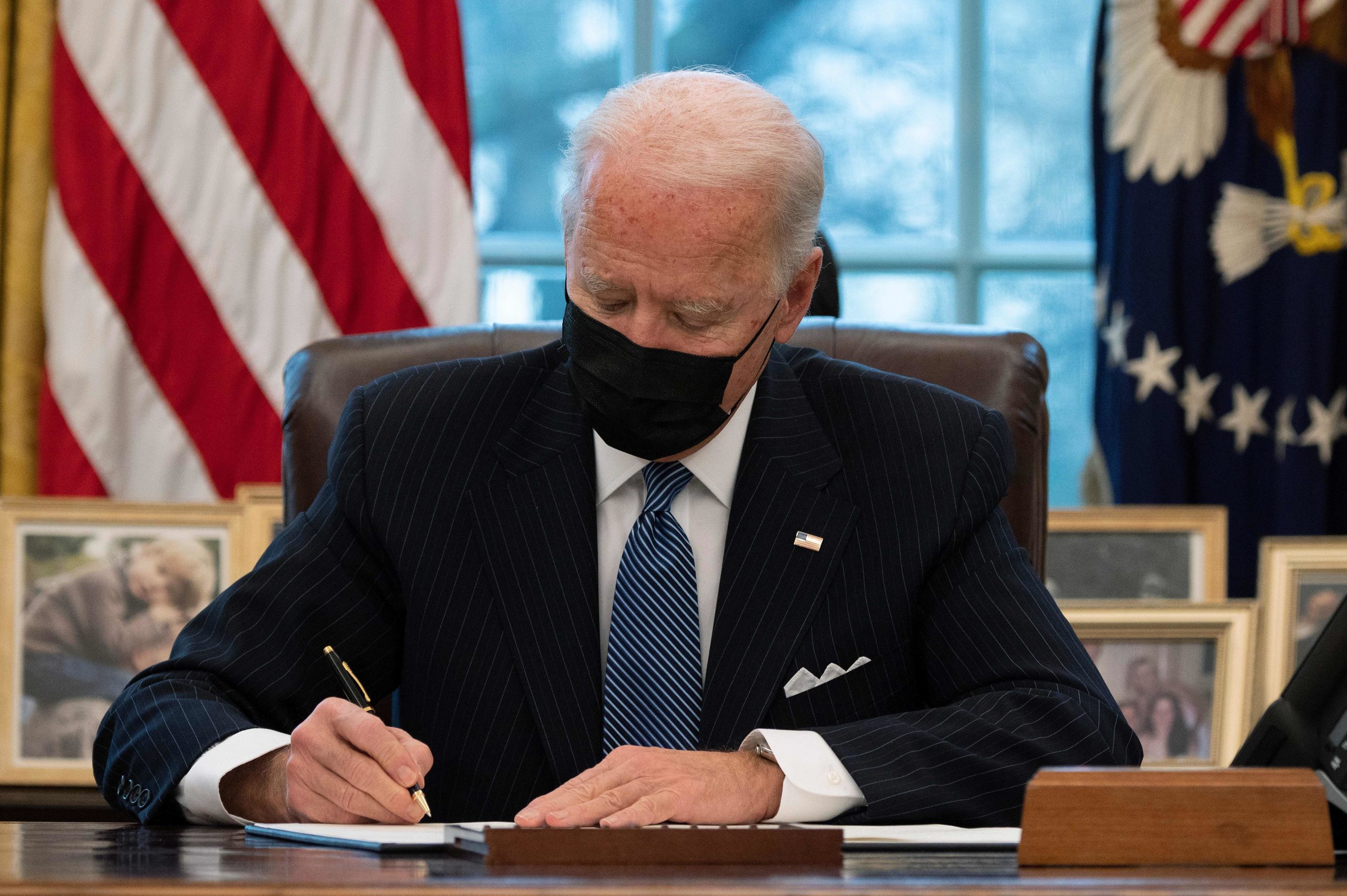 President Joe Biden signs an Executive Order reversing Trump era ban on Transgender serving in the military while in the Oval Office of the White House in Washington, DC, on January 25, 2021. (JIM WATSON/AFP via Getty Images)