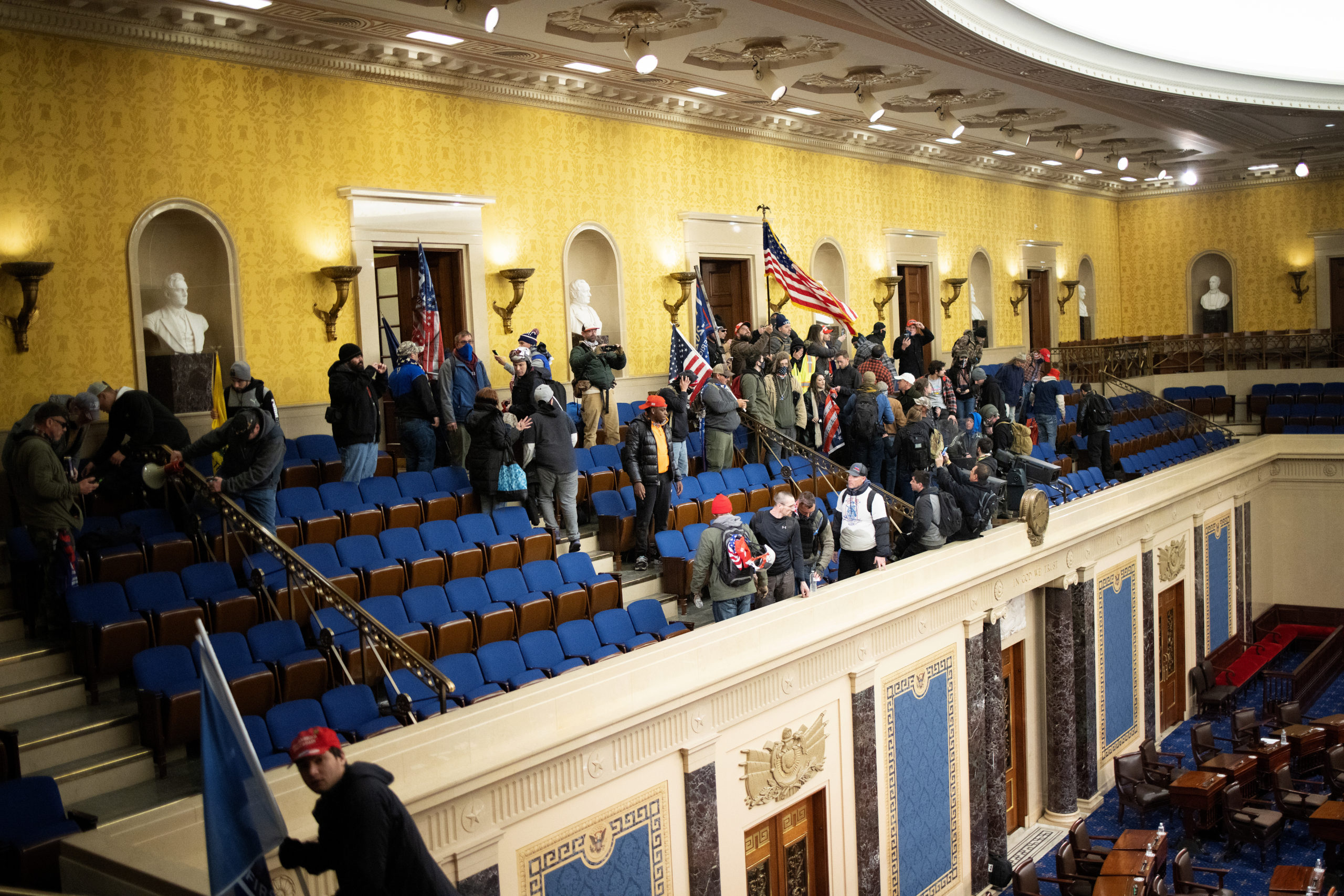 WASHINGTON, DC - JANUARY 06: A pro-Trump mob gathers inside the Senate chamber in the U.S. Capitol after groups stormed the building on January 06, 2021 in Washington, DC. Congress held a joint session today to ratify President-elect Joe Biden's 306-232 Electoral College win over President Donald Trump. A group of Republican senators said they would reject the Electoral College votes of several states unless Congress appointed a commission to audit the election results. (Photo by Win McNamee/Getty Images)