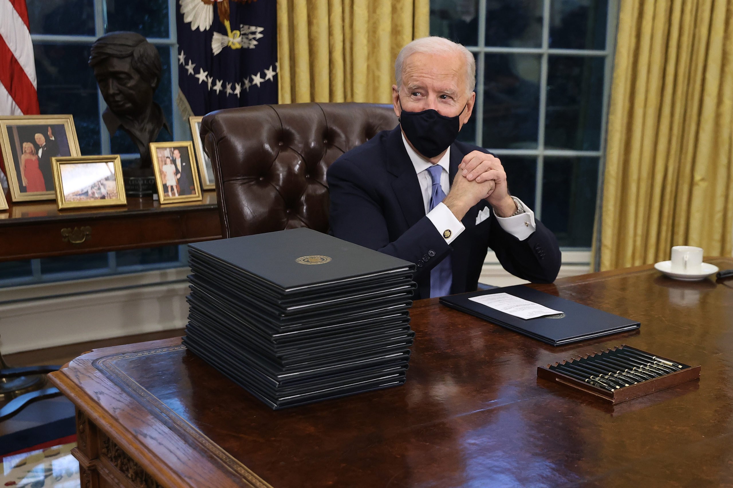 WASHINGTON, DC - JANUARY 20: U.S. President Joe Biden prepares to sign a series of executive orders at the Resolute Desk in the Oval Office just hours after his inauguration on January 20, 2021 in Washington, DC. Biden became the 46th president of the United States earlier today during the ceremony at the U.S. Capitol. (Photo by Chip Somodevilla/Getty Images)