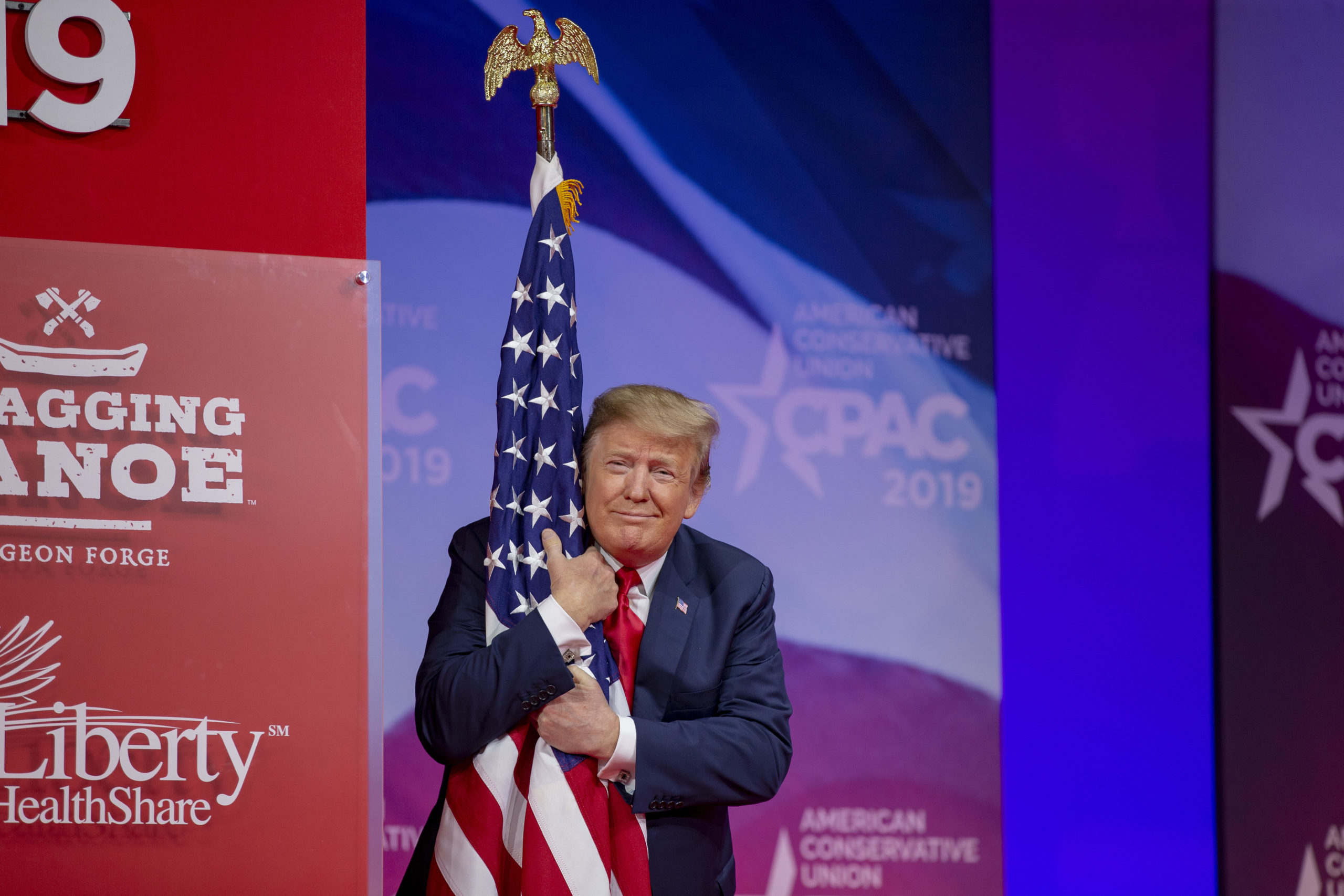 NATIONAL HARBOR, MD - MARCH 02: (AFP OUT) U.S. President Donald Trump hugs the U.S. flag during CPAC 2019 on March 02, 2019 in National Harbor, Maryland. The American Conservative Union hosts the annual Conservative Political Action Conference to discuss conservative agenda. (Photo by Tasos Katopodis/Getty Images)