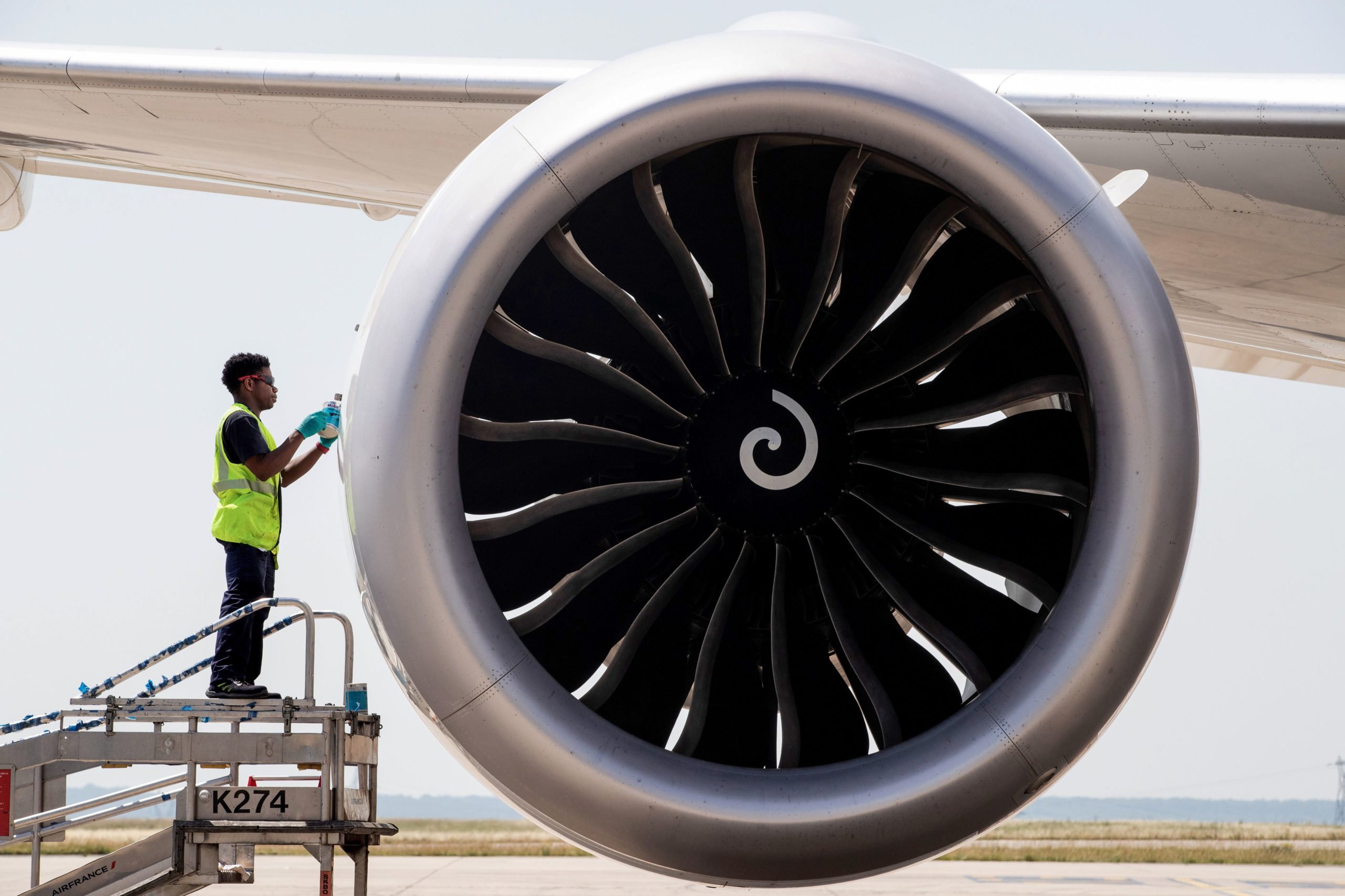 An airport worker checks the engine of a Boeing 787 of the airline company Air France parked in the tarmac at Roissy-Charles de Gaulle Airport, in Roissy, north of Paris, on June 27, 2019. (Photo by JOEL SAGET / AFP) (Photo credit should read JOEL SAGET/AFP via Getty Images)