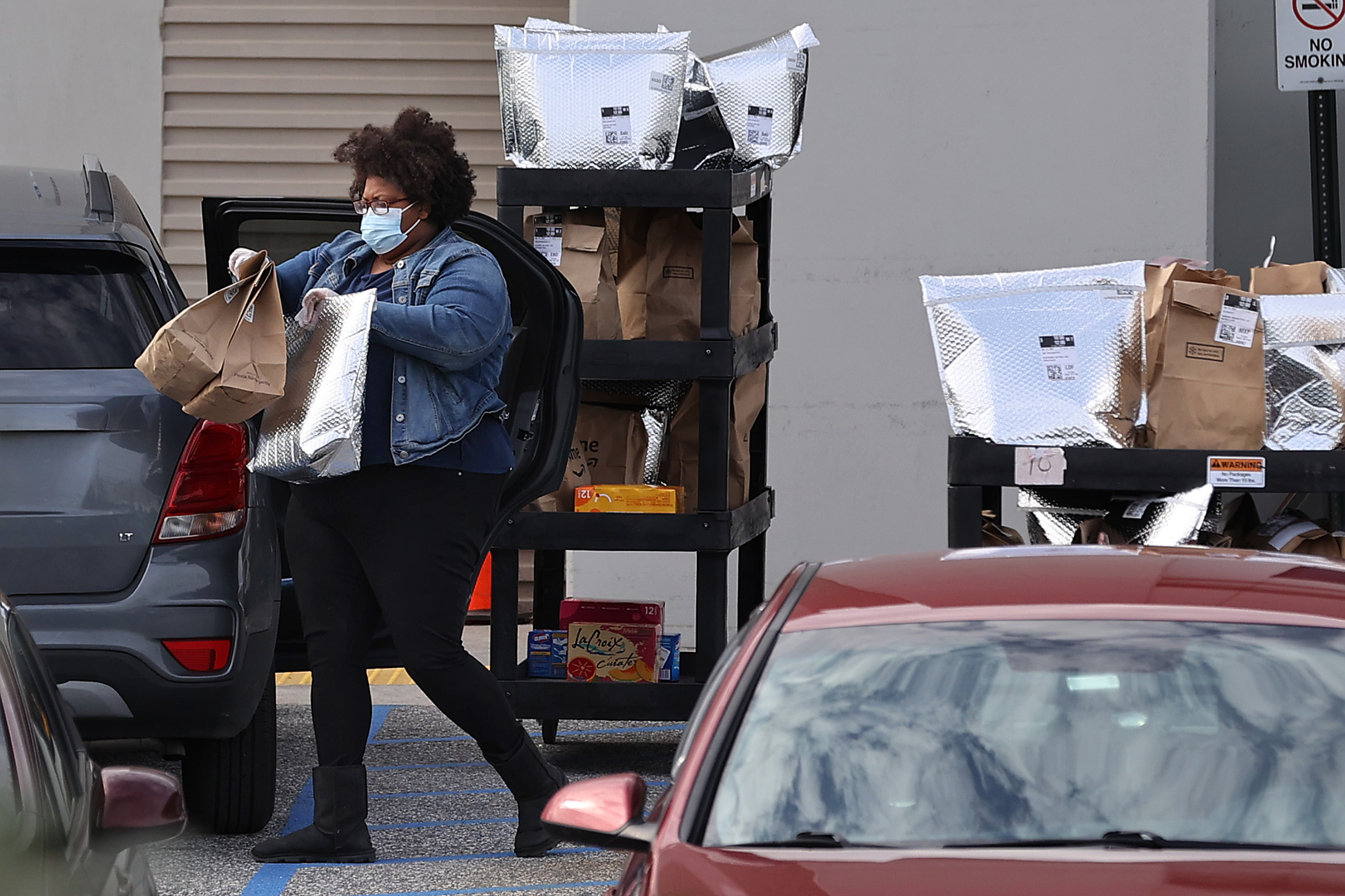 An Amazon Flex driver loads their personal vehicle with packages outside the 1.2 million-square-foot BWI2 Amazon Fulfillment Center in the Chesapeake Commerce Center April 14, 2020 in Baltimore, Maryland. While some workers across the country have expressed concern about what steps Amazon is doing to protect workers from COVID-19, the online retailer hired 100,000 people in March says it wants to add another 75,000 full and part-time jobs due to rising demand during the coronavirus pandemic. (Photo by Chip Somodevilla/Getty Images)