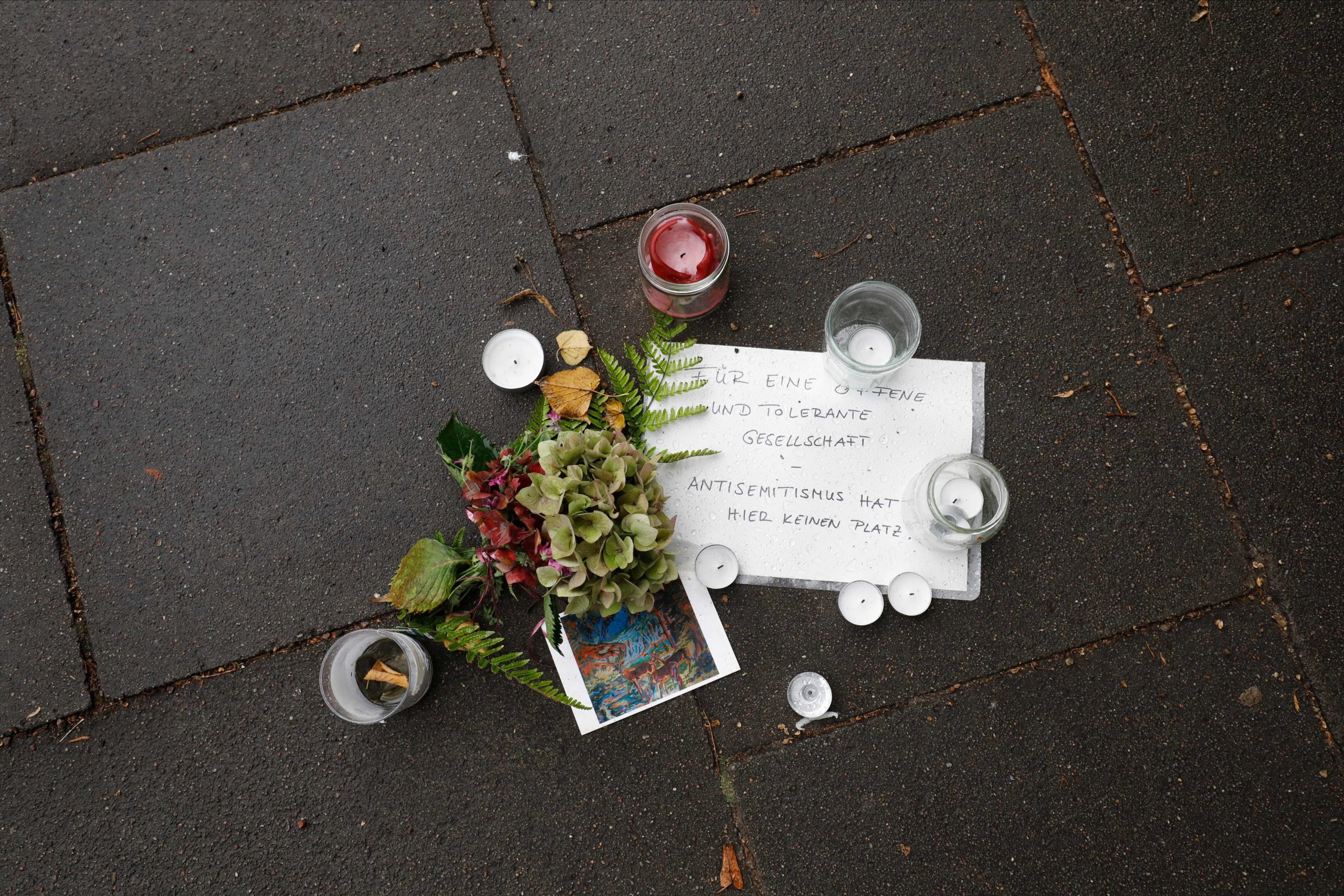 Flowers, candles and a message reading "For an open and tolerant society - Antisemitism has no place here" are pictured in front of the Synagoge 'Hohe Weide' in Hamburg, northern Germeny, on Oktober 5, 2020, one day after an attack on a Jewish student. - A Jewish student was badly injured on Sunday, October 4, 2020, after a man attacked him with a shovel outside the synagogue. Police assigned to protect the synagogue arrested a 29-year-old man who was wearing a uniform resembling that of the Germany army. (Photo by MORRIS MAC MATZEN / AFP) (Photo by MORRIS MAC MATZEN/AFP via Getty Images)