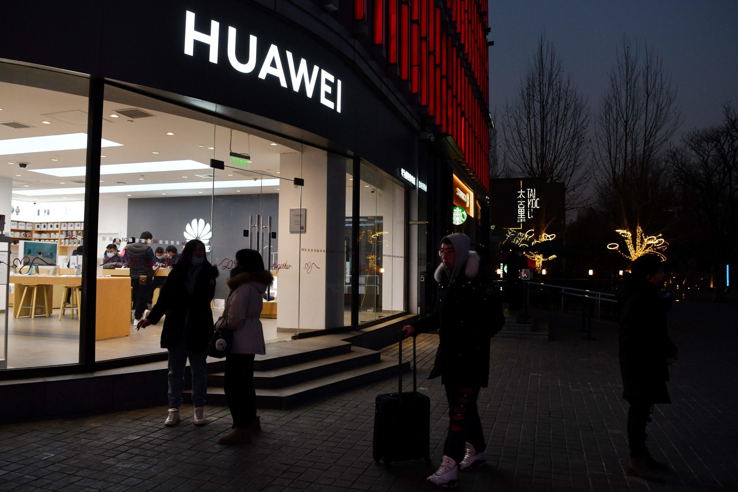 People stand outside a Huawei store in Beijing on Jan. 29. (Greg Baker/AFP via Getty Images)