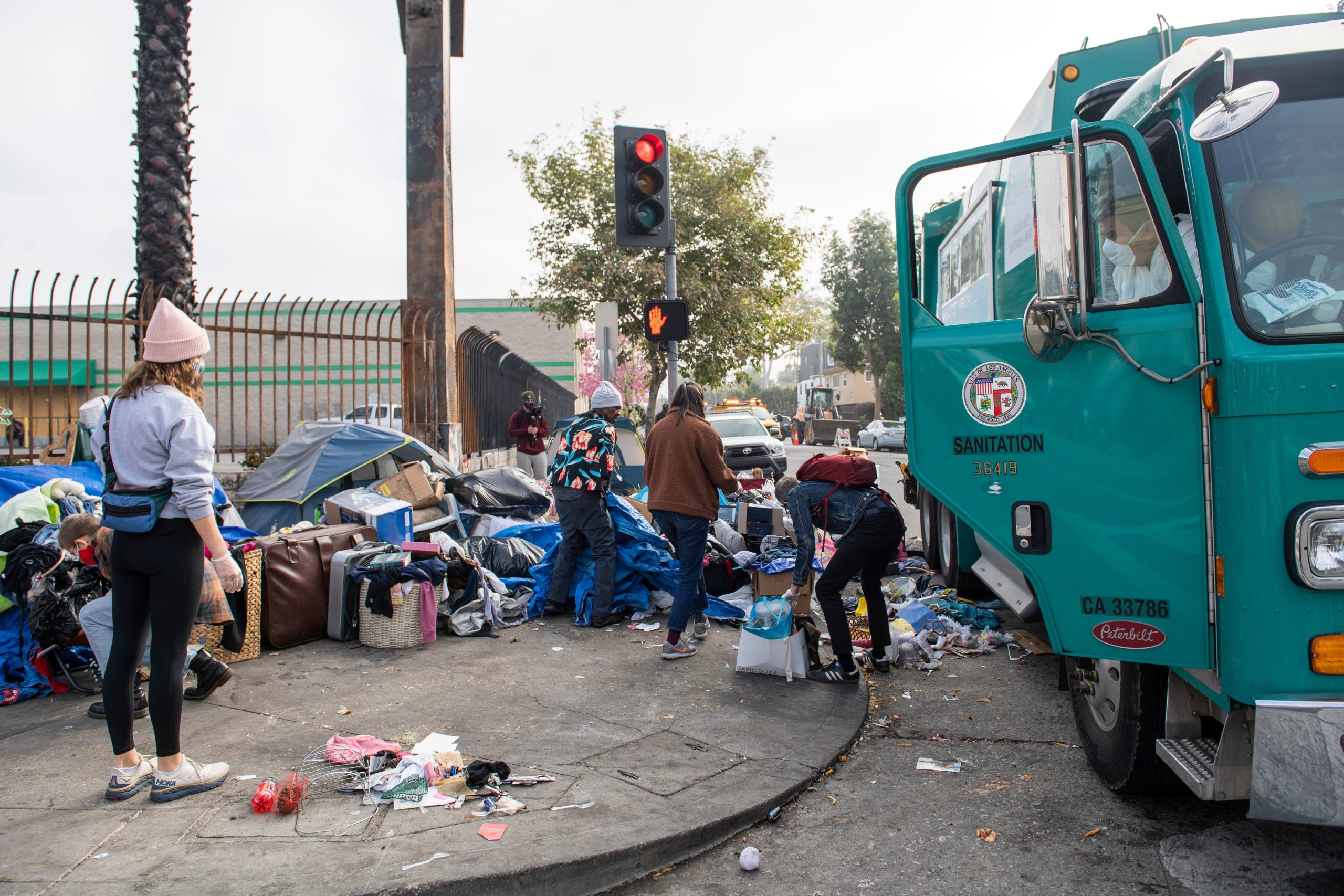 Activists help protect homeless from being displaced by street cleaning and power washing from the Los Angeles Sanitation service on Feb. 8 in Hollywood, California. (Valerie Macon/AFP via Getty Images)