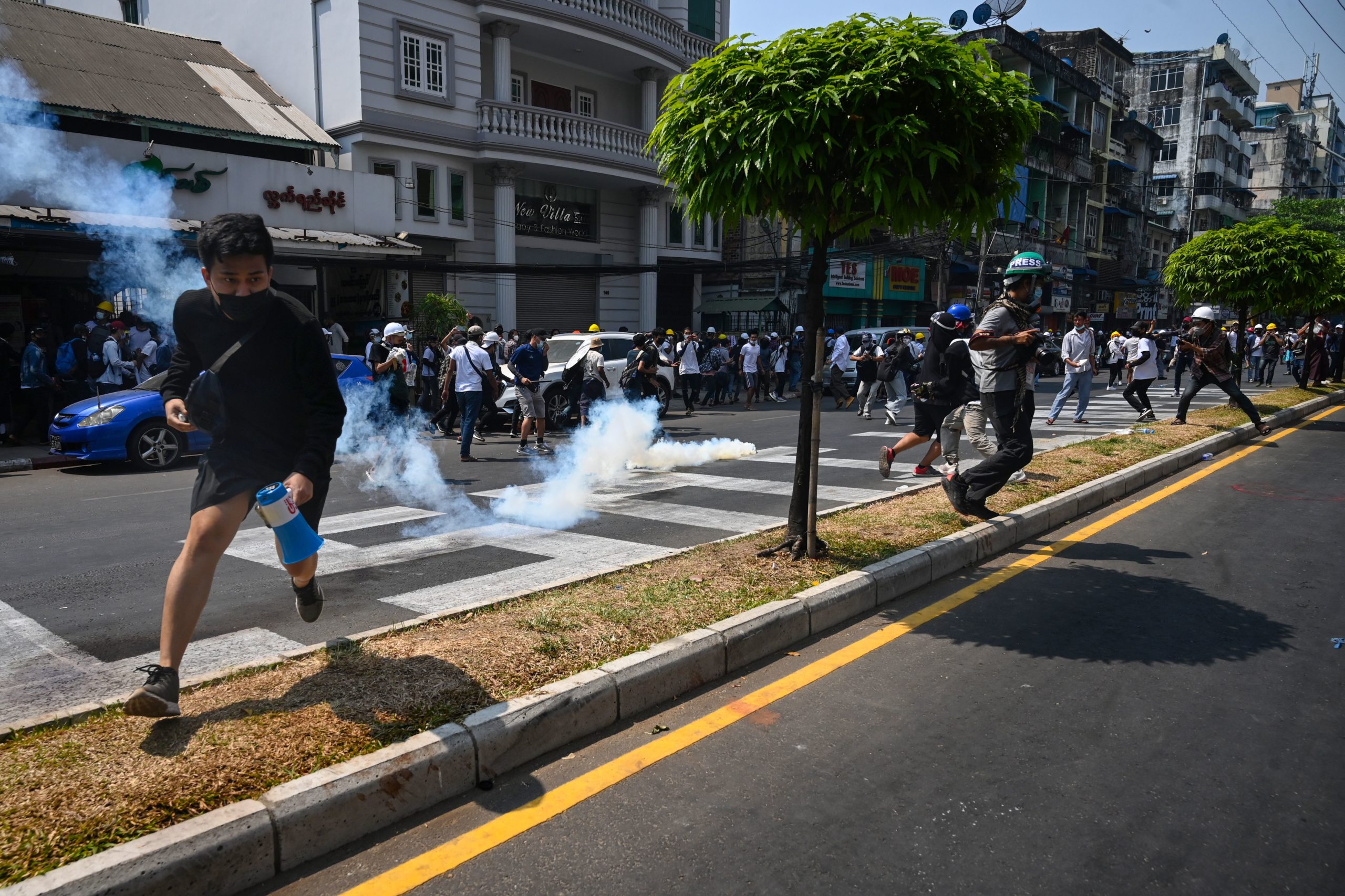 Protesters run after police fired tear gas to disperse them during a demonstration against the military coup in Yangon on February 28, 2021. (Photo by Sai Aung Main / AFP) (Photo by SAI AUNG MAIN/AFP via Getty Images)